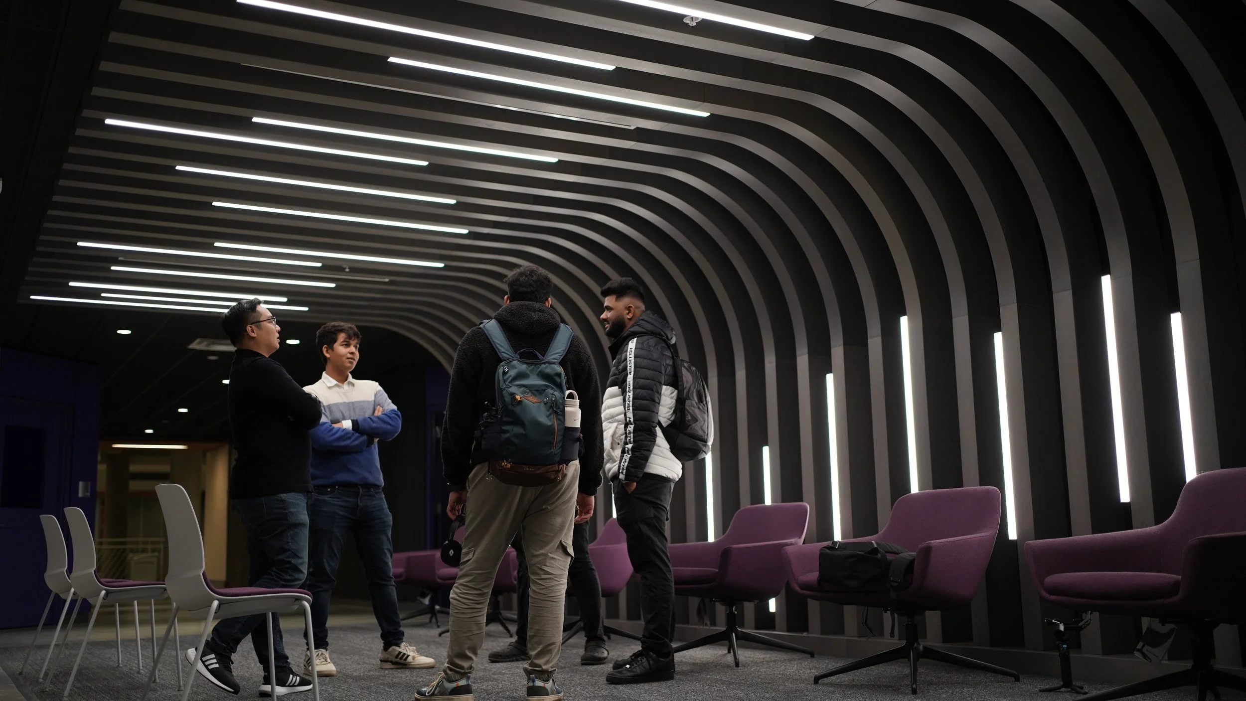 Four people talking together in a campus lounge.
