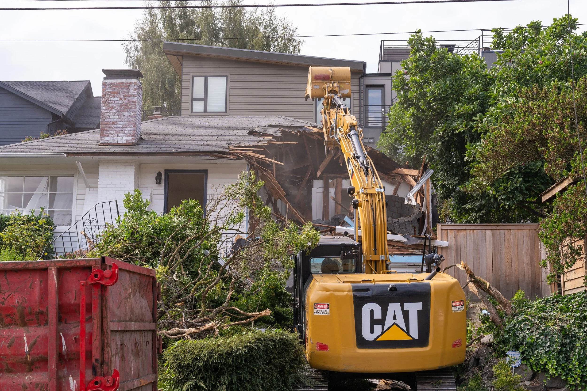 Excavator taking down a residential structure