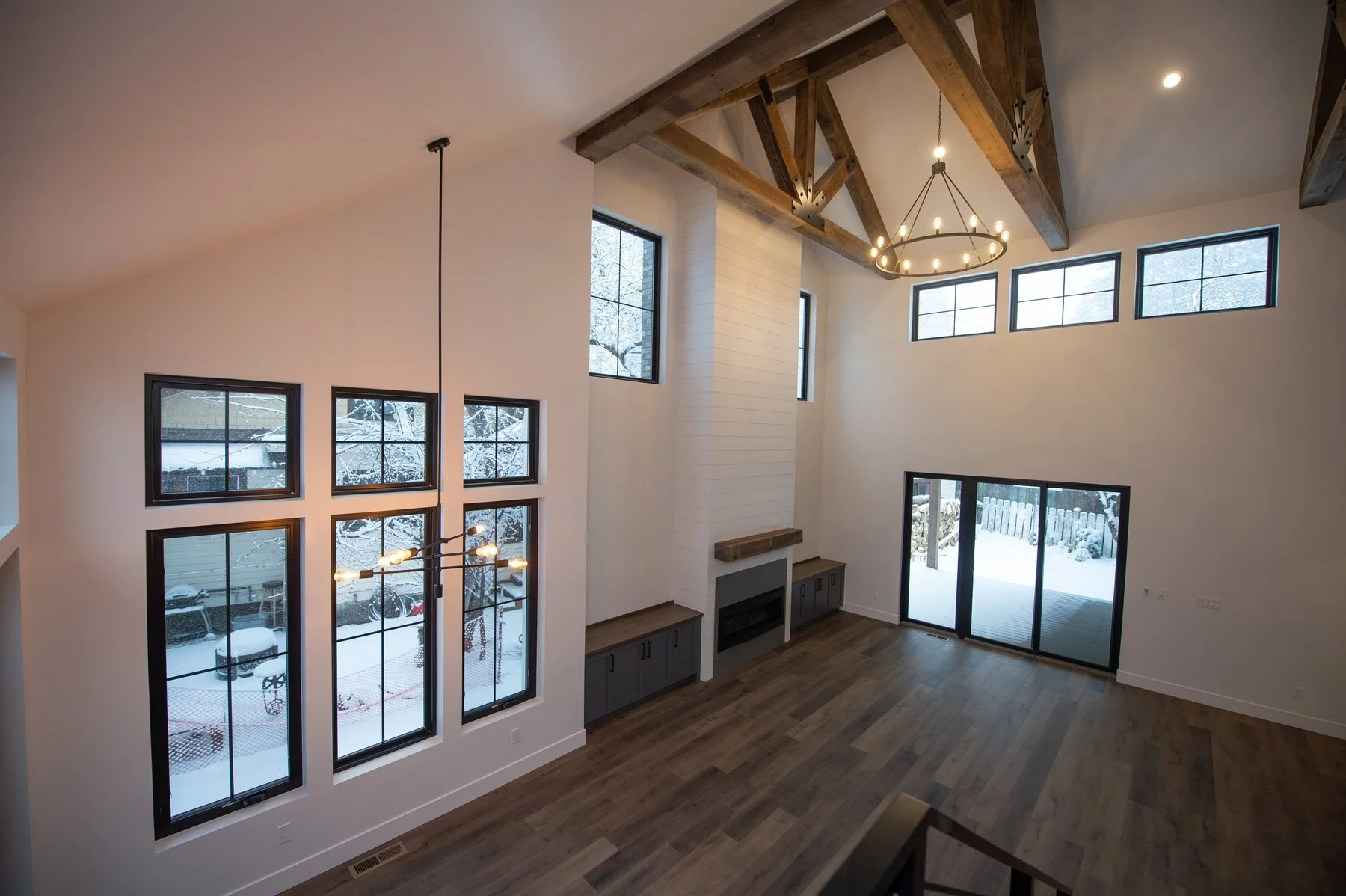 State Street, a custom home in Bend with a vaulted great room, reclaimed timber trusses, black-framed windows and a shiplap fireplace wall