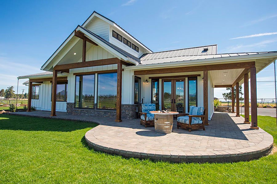 Modern Farmhouse, a white board-and-batten custom home with a metal roof, timber posts and a covered paver patio