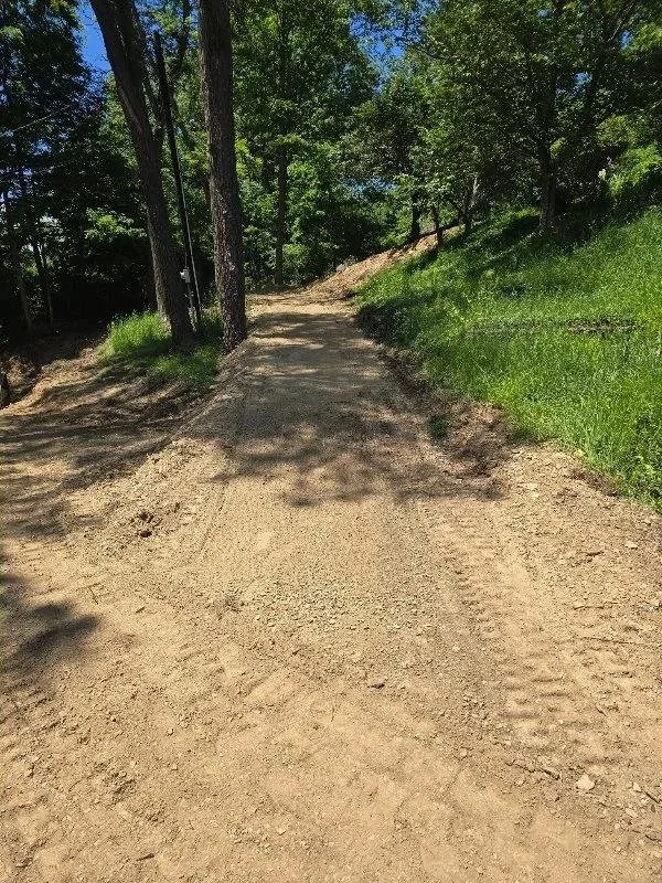 Cleared dirt path through the wooded slope after grading