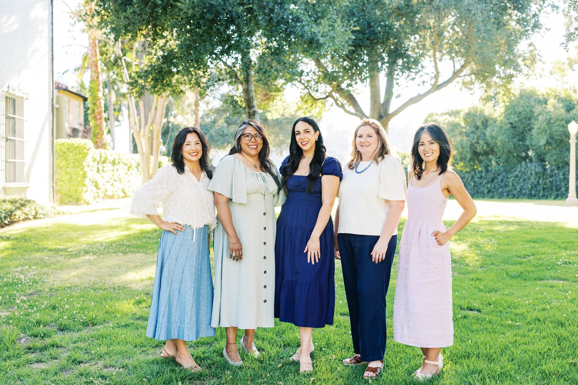 Five members of Village East standing together outdoors.