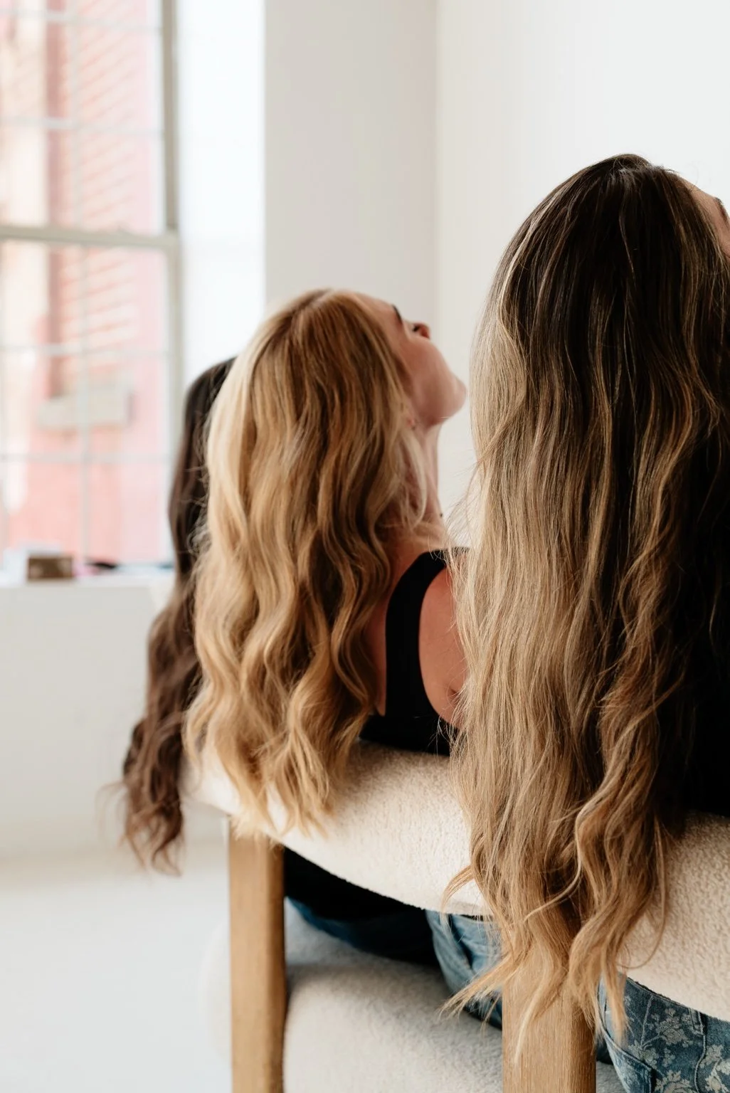 Long dimensional hairstyles photographed beside a studio window