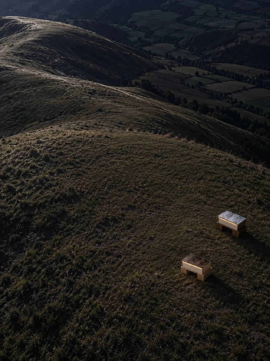 Two nightstands in an expansive grassy mountain landscape.
