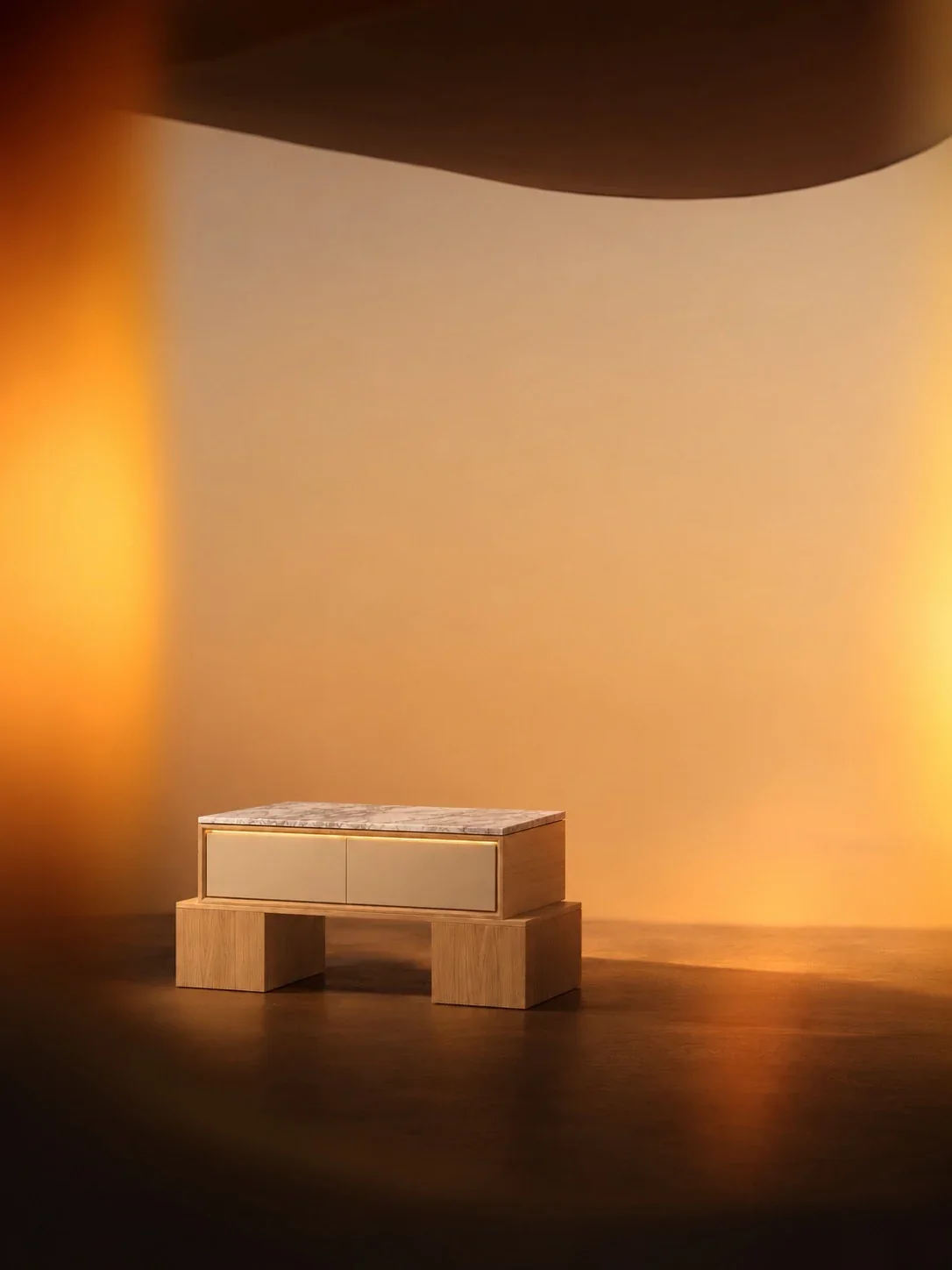 Single light oak and Carrara nightstand in a sculptural amber-lit interior.