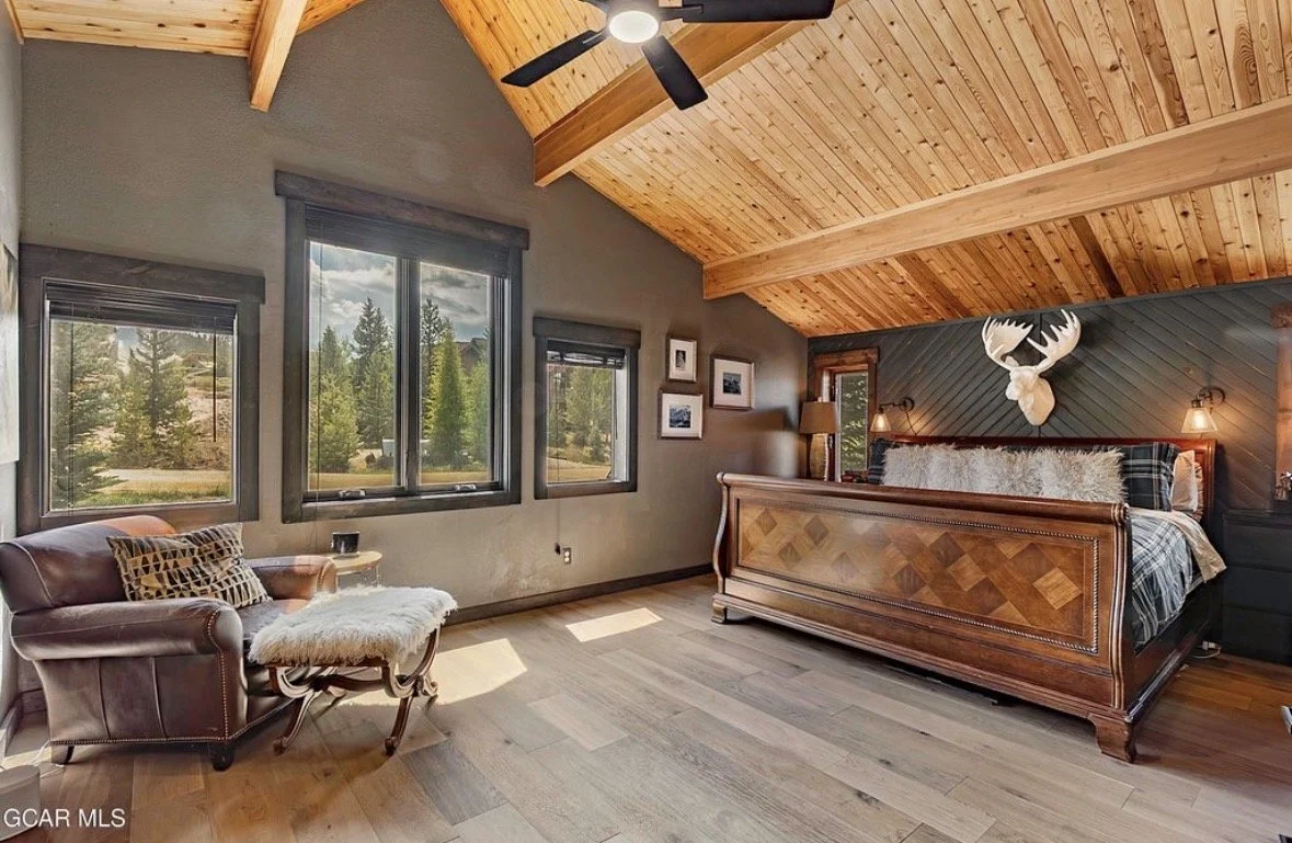 The top floor suite with a vaulted wood ceiling, a king sleigh bed and a leather reading chair