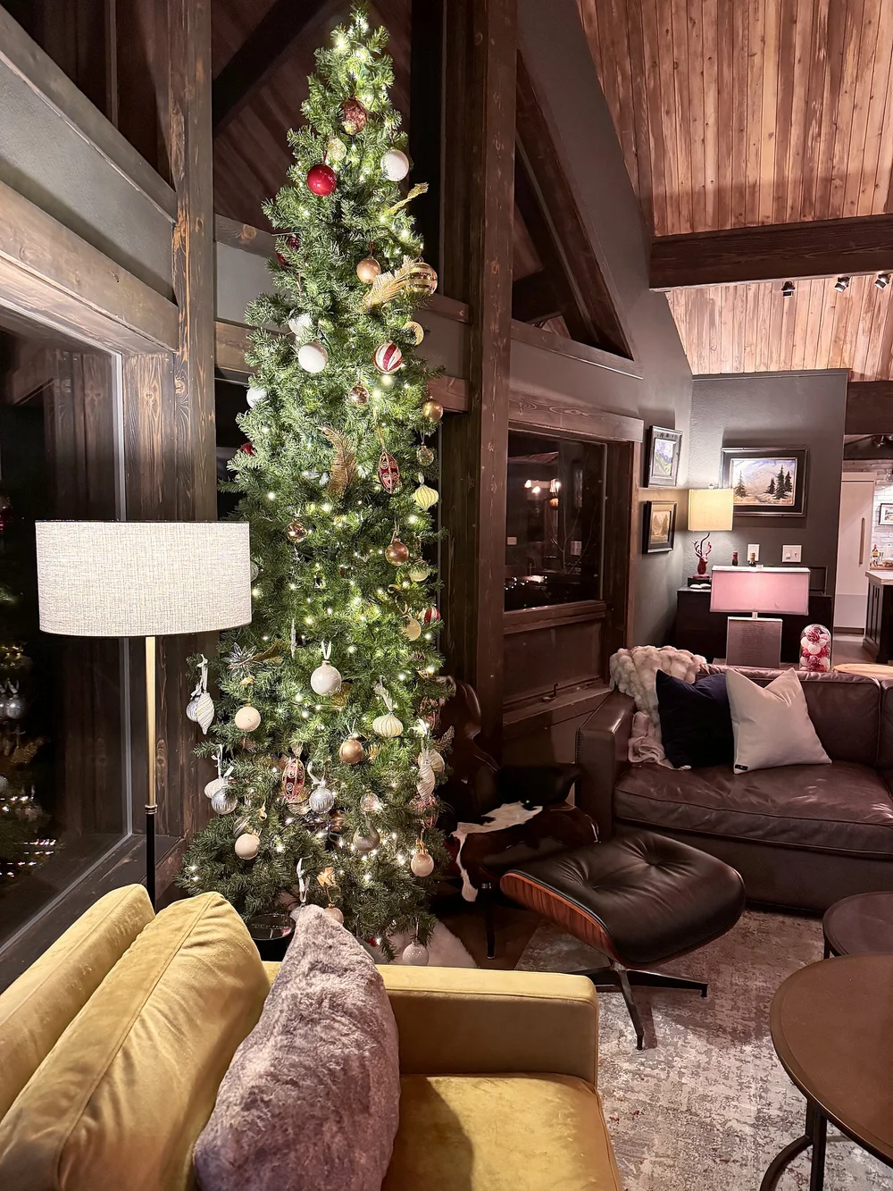 A tall decorated Christmas tree beside the two-story windows in the great room