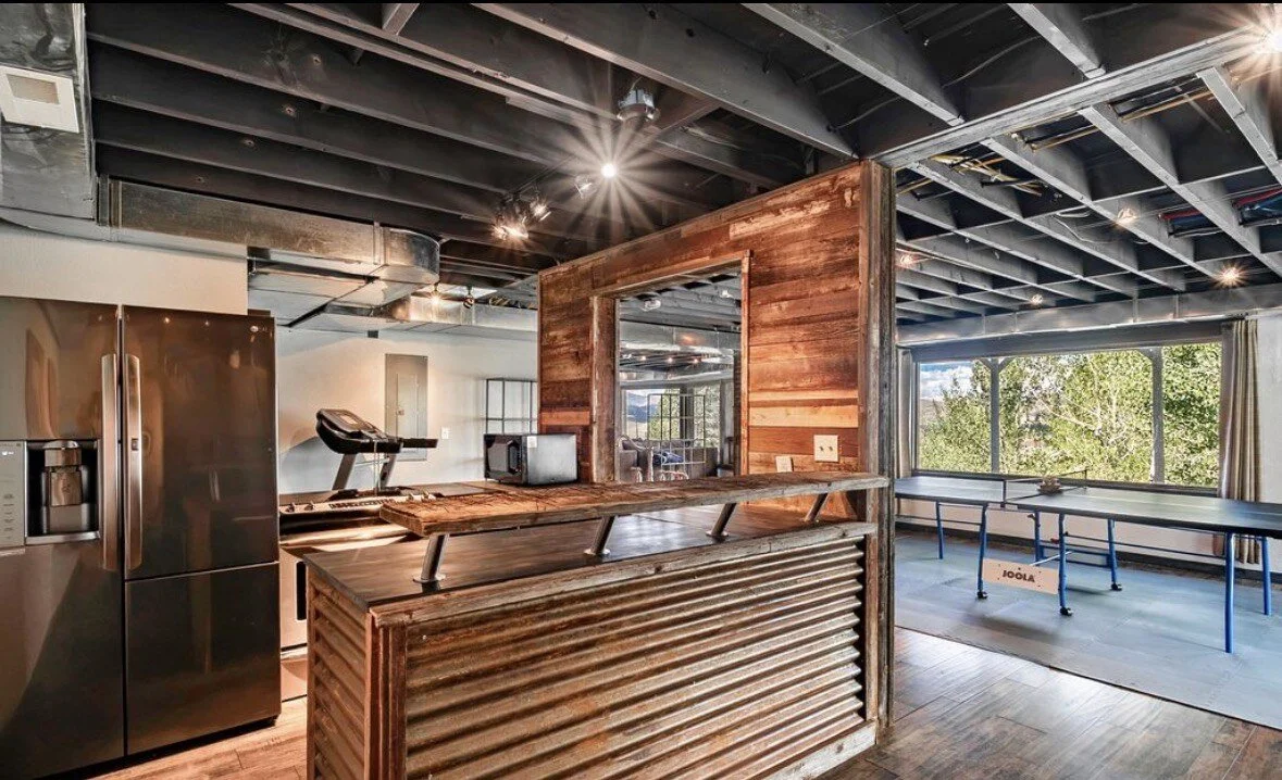 The reclaimed-wood bar beside the ping pong table on the lower level