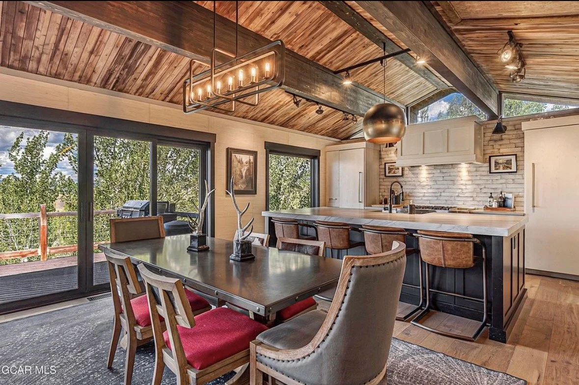 The dining table for eight beside sliding doors to the deck