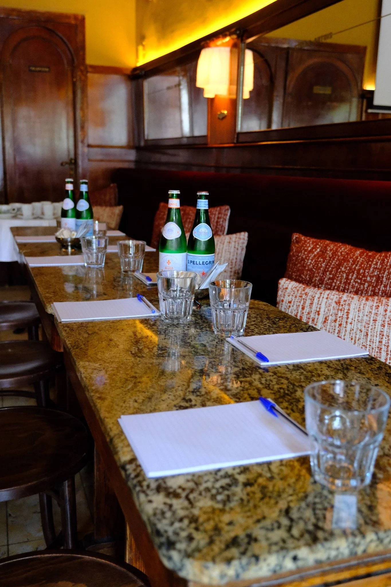 Vergadertafel bij Petit Midi met notitieblokken, pennen en water