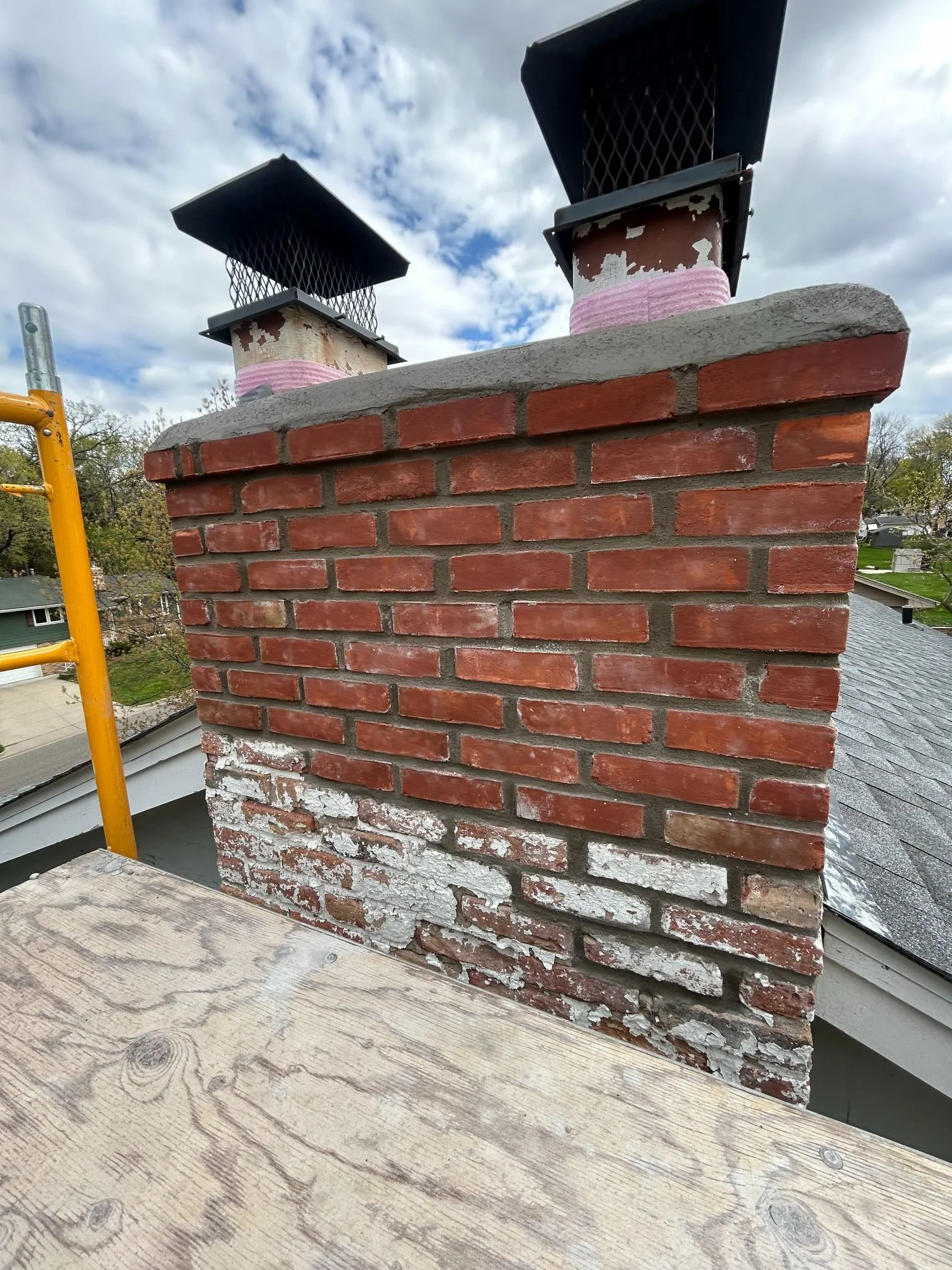 A Golden Stones mason repointing mortar joints beneath a window