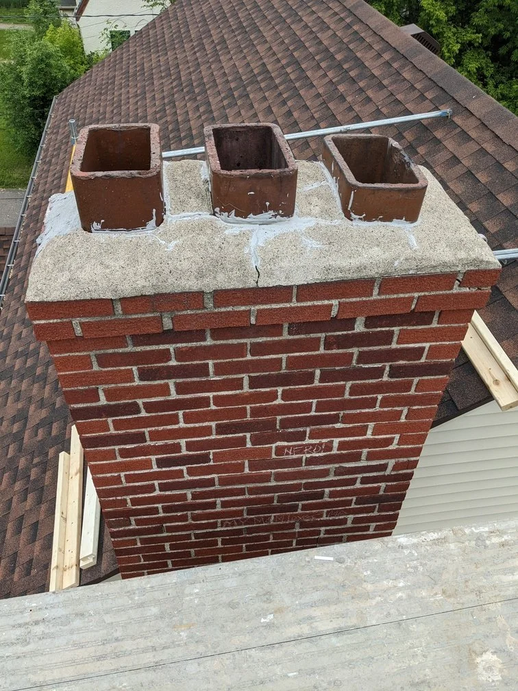 A Golden Stones mason grinding failed mortar out of the joints on a brick wall