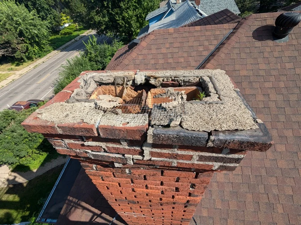 A Golden Stones mason grinding failed mortar out of the joints on a brick wall