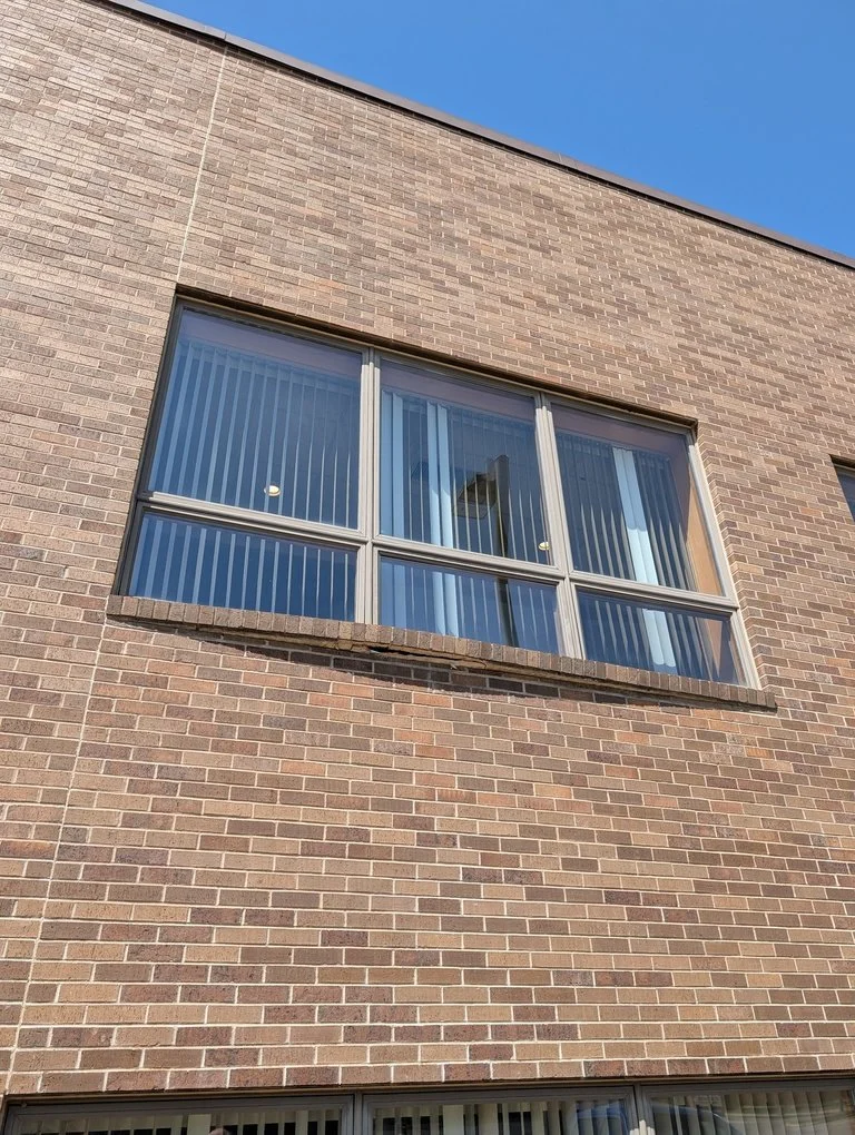 A rebuilt brick chimney stack with a new concrete crown