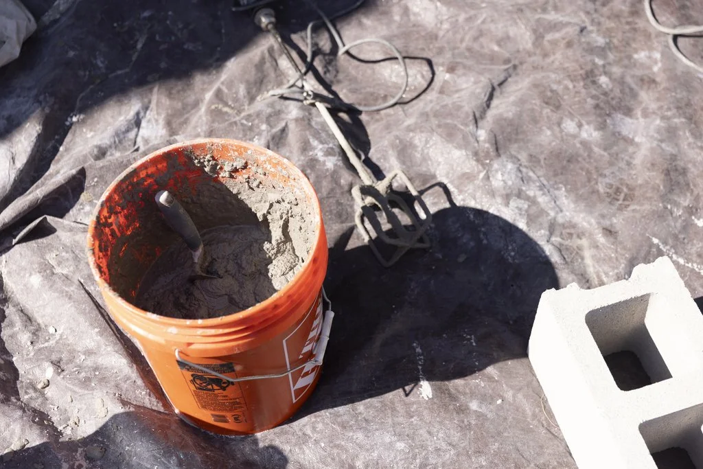 A Golden Stones mason grinding failed mortar out of the joints on a brick wall