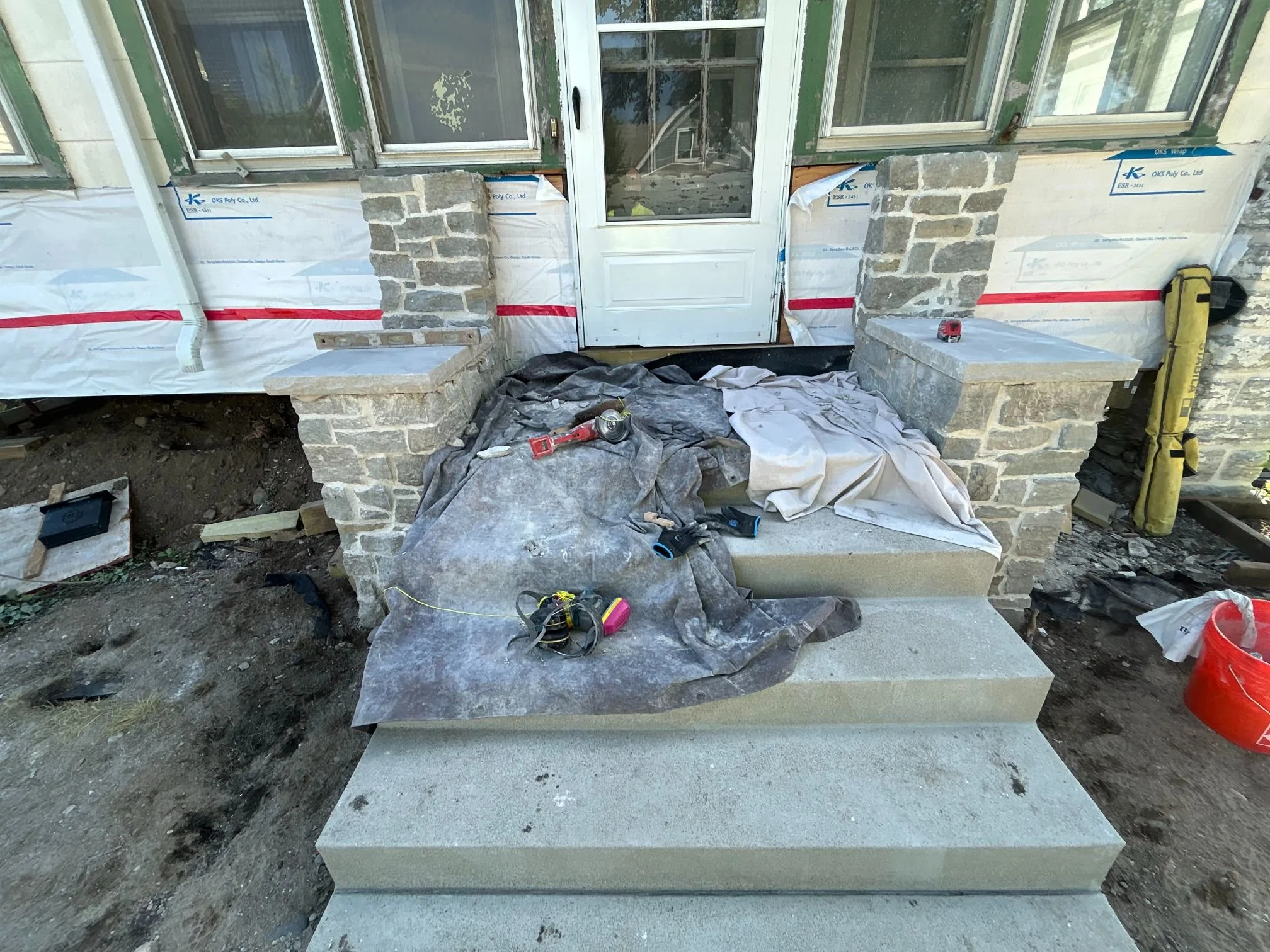 A stone side wall running up the edge of a set of front steps