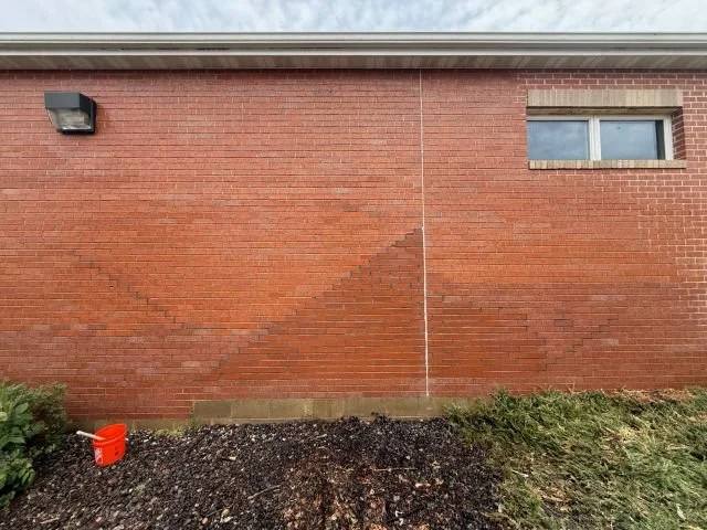 A rebuilt brick chimney stack with a new concrete crown