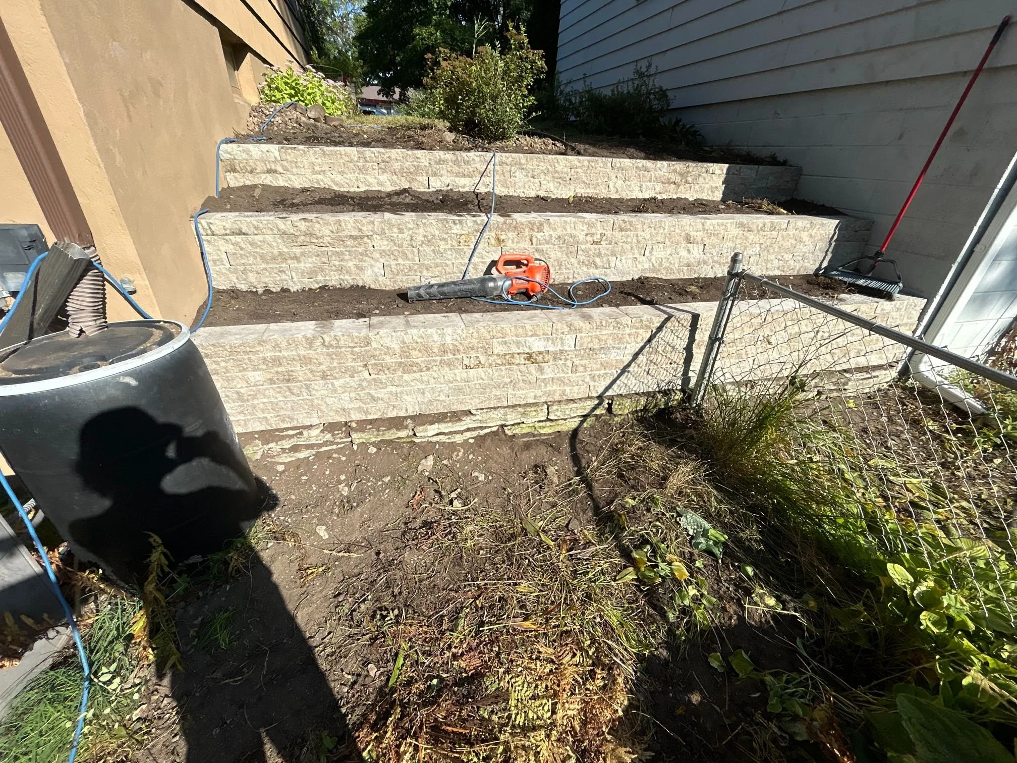 A Golden Stones mason grinding failed mortar out of the joints on a brick wall