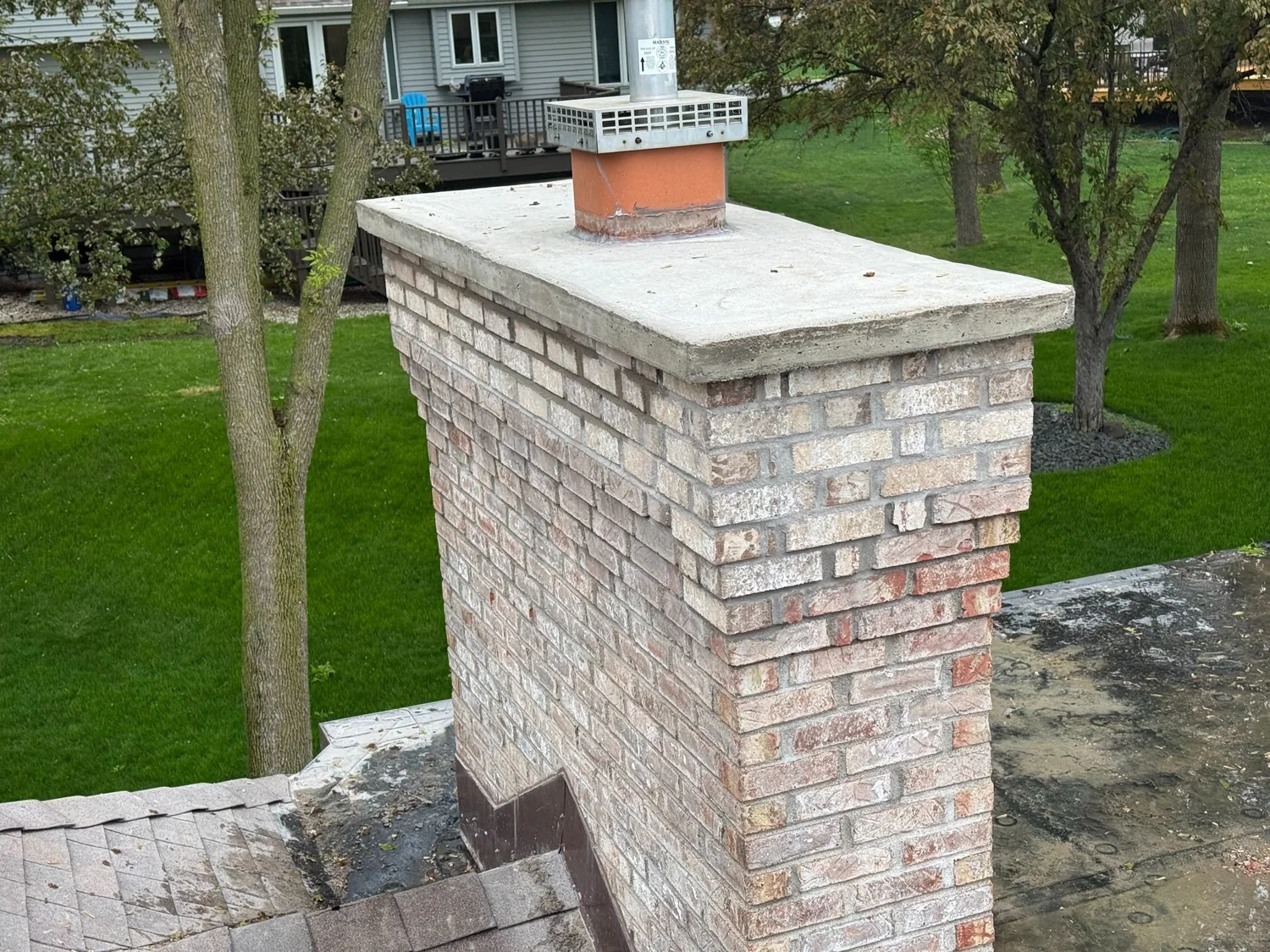 A rebuilt brick chimney with a new crown