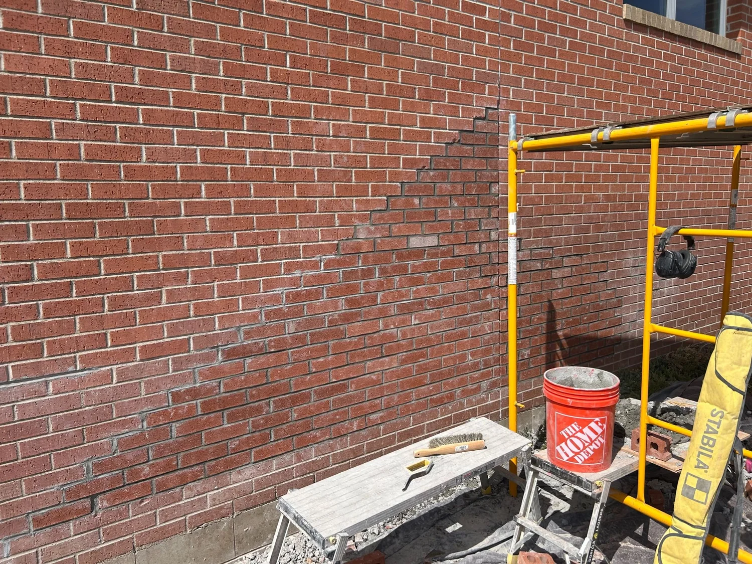 A brick and block wall part-way through a rebuild