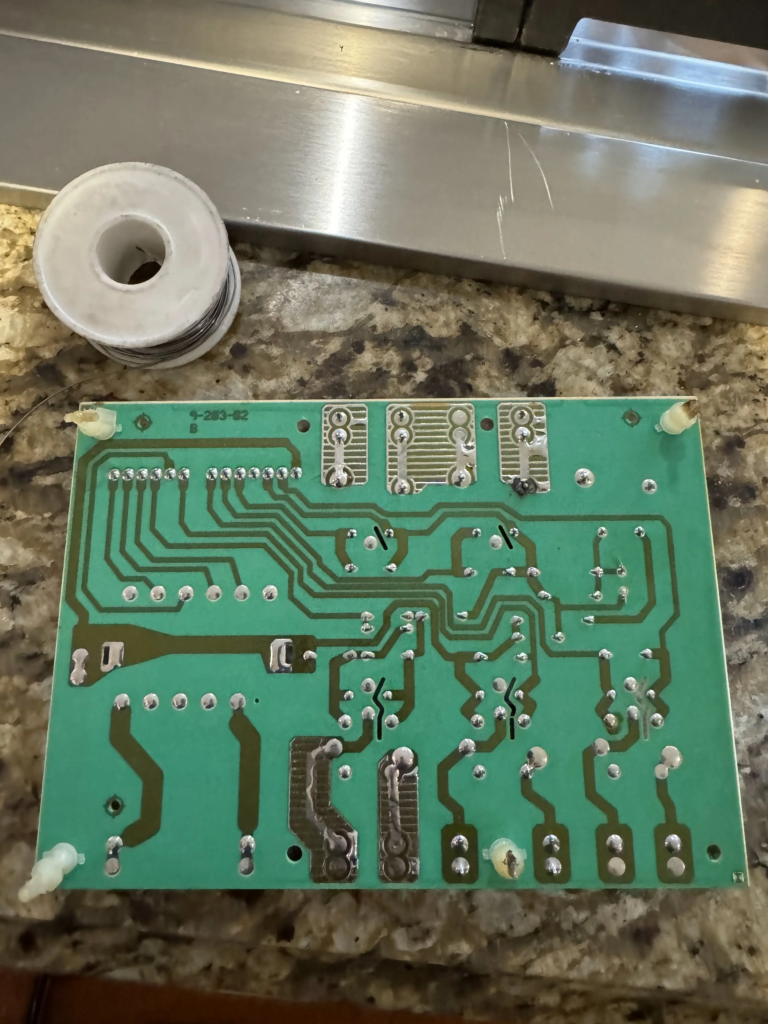Bare appliance control board during a microwave repair in Spokane