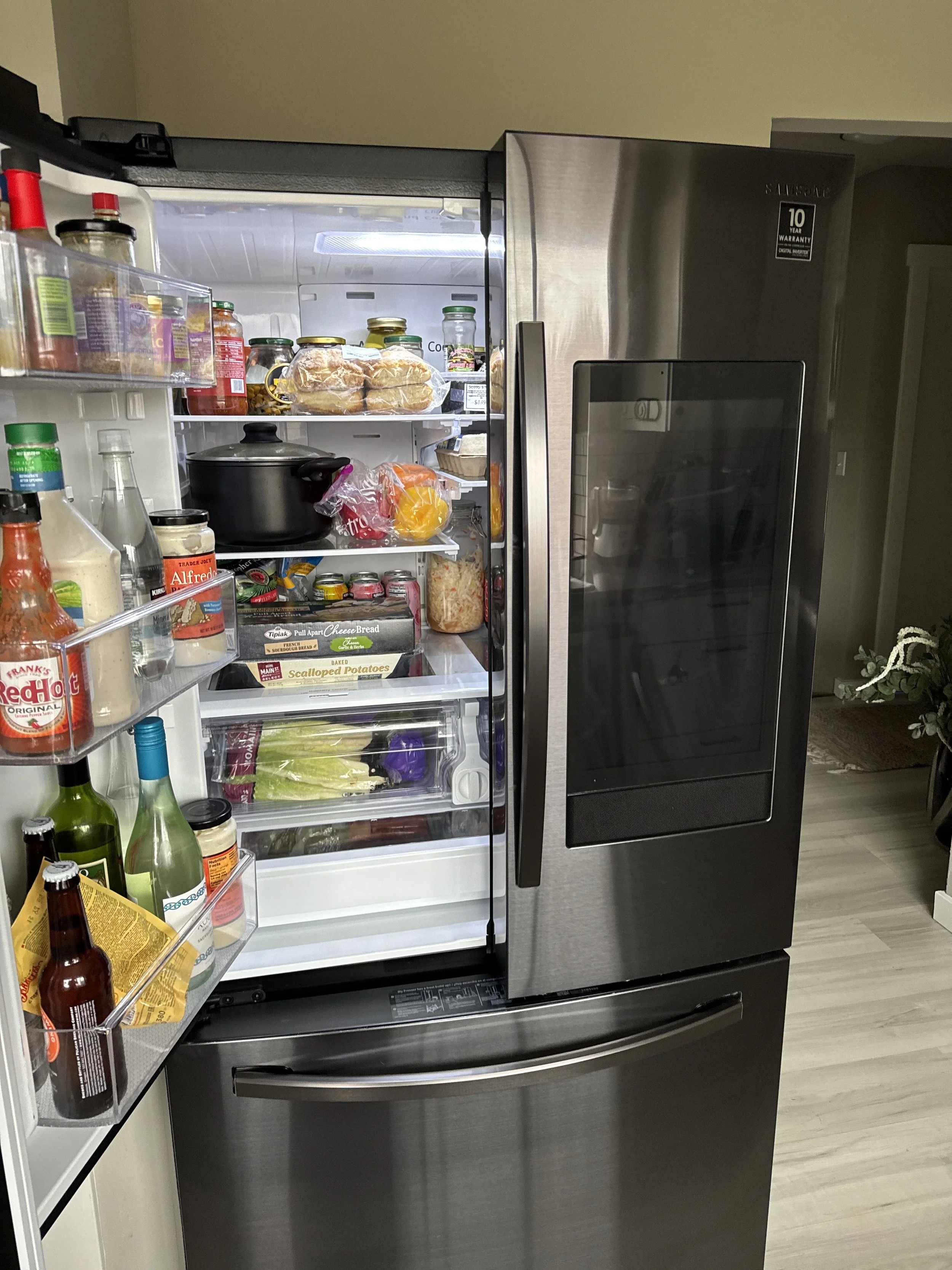 Refrigerator door open with shelves packed with food, the first thing to check when a refrigerator in Coeur d'Alene is not cooling