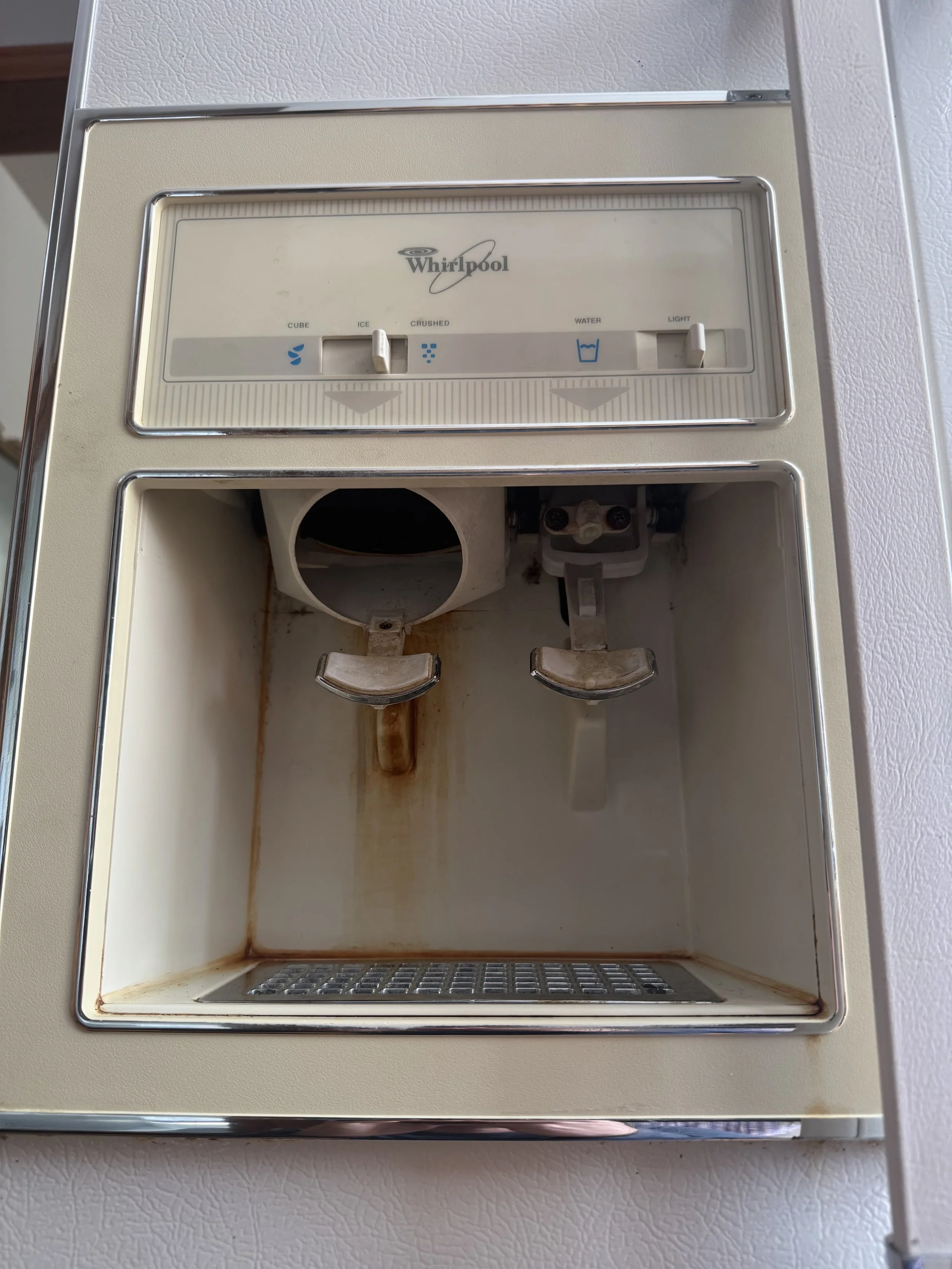 Ice maker mechanism in a refrigerator door