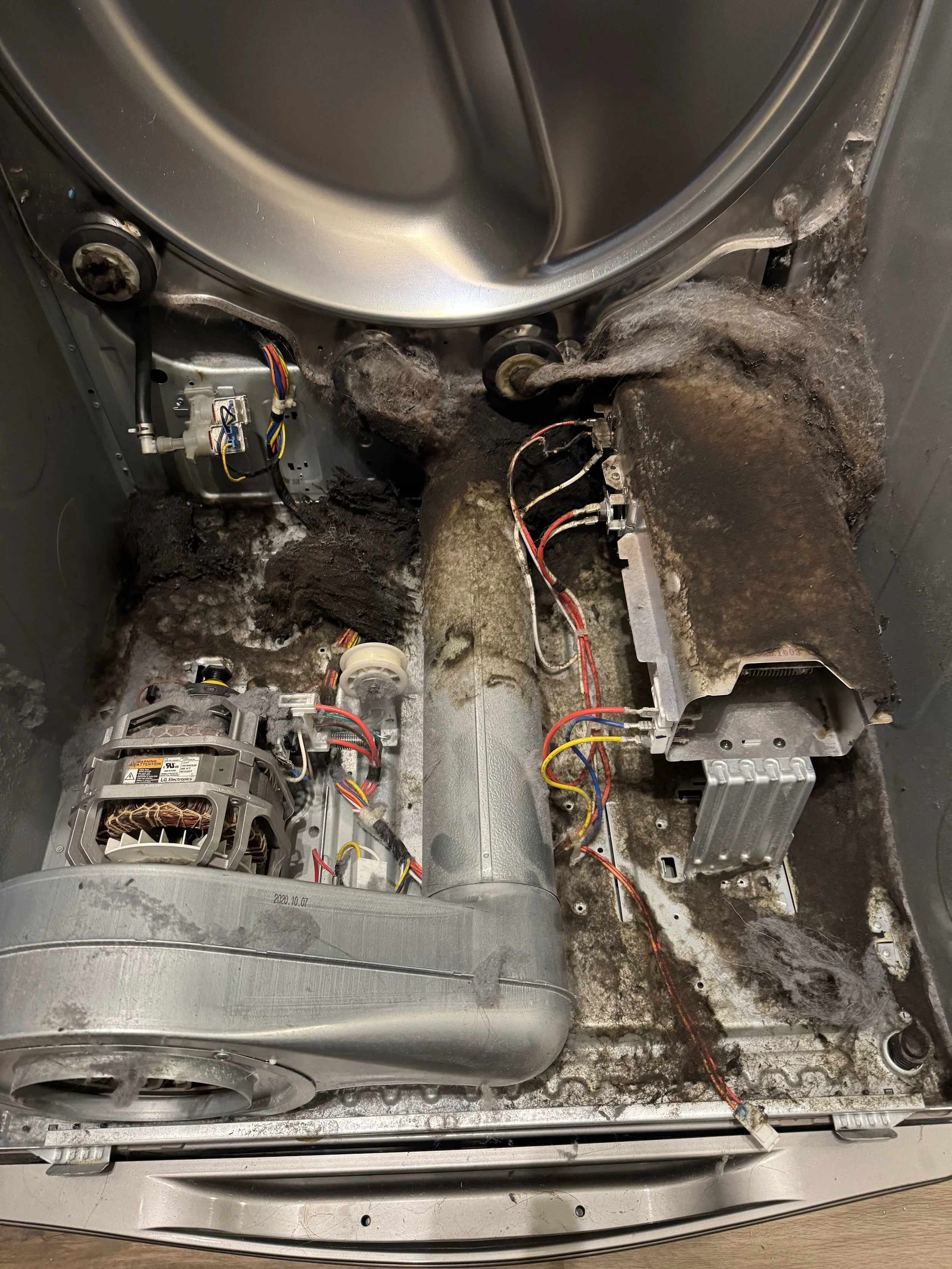 A dryer interior heavily clogged with lint