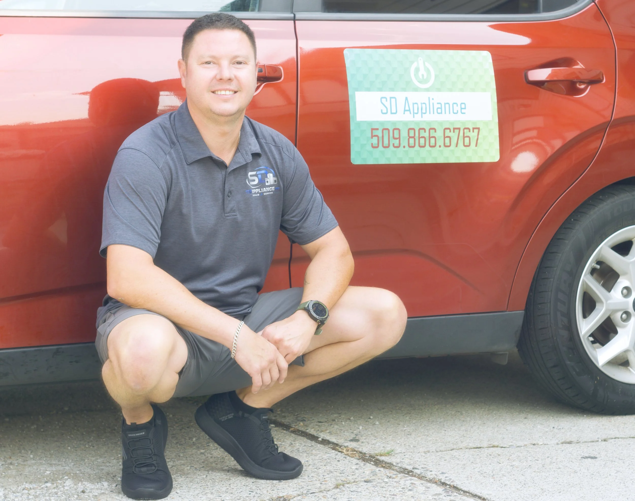 Sergei by the van with the phone-number decal during an appliance repair in Spokane Valley by SD Appliance