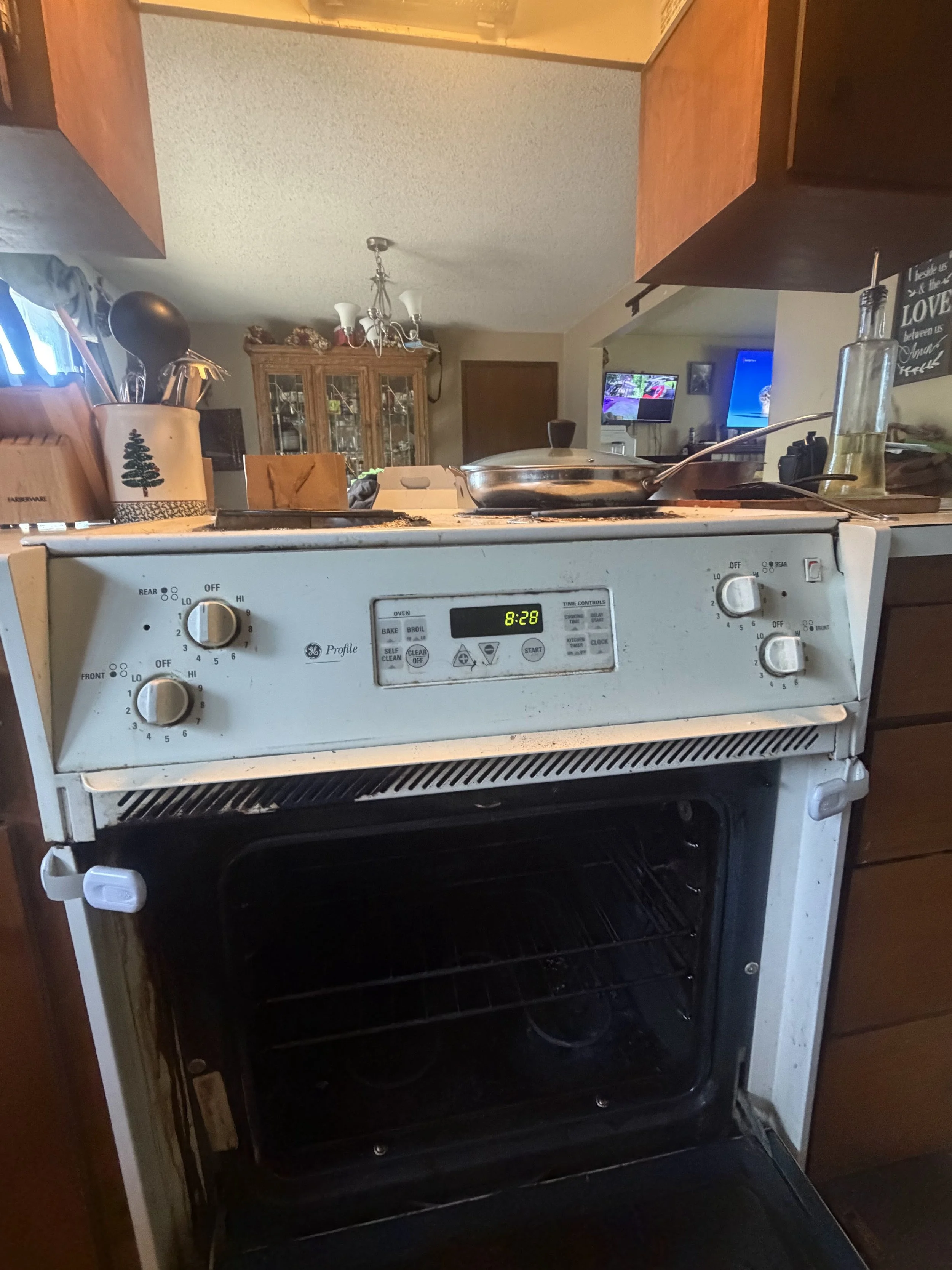 A white range with dial controls in an older kitchen