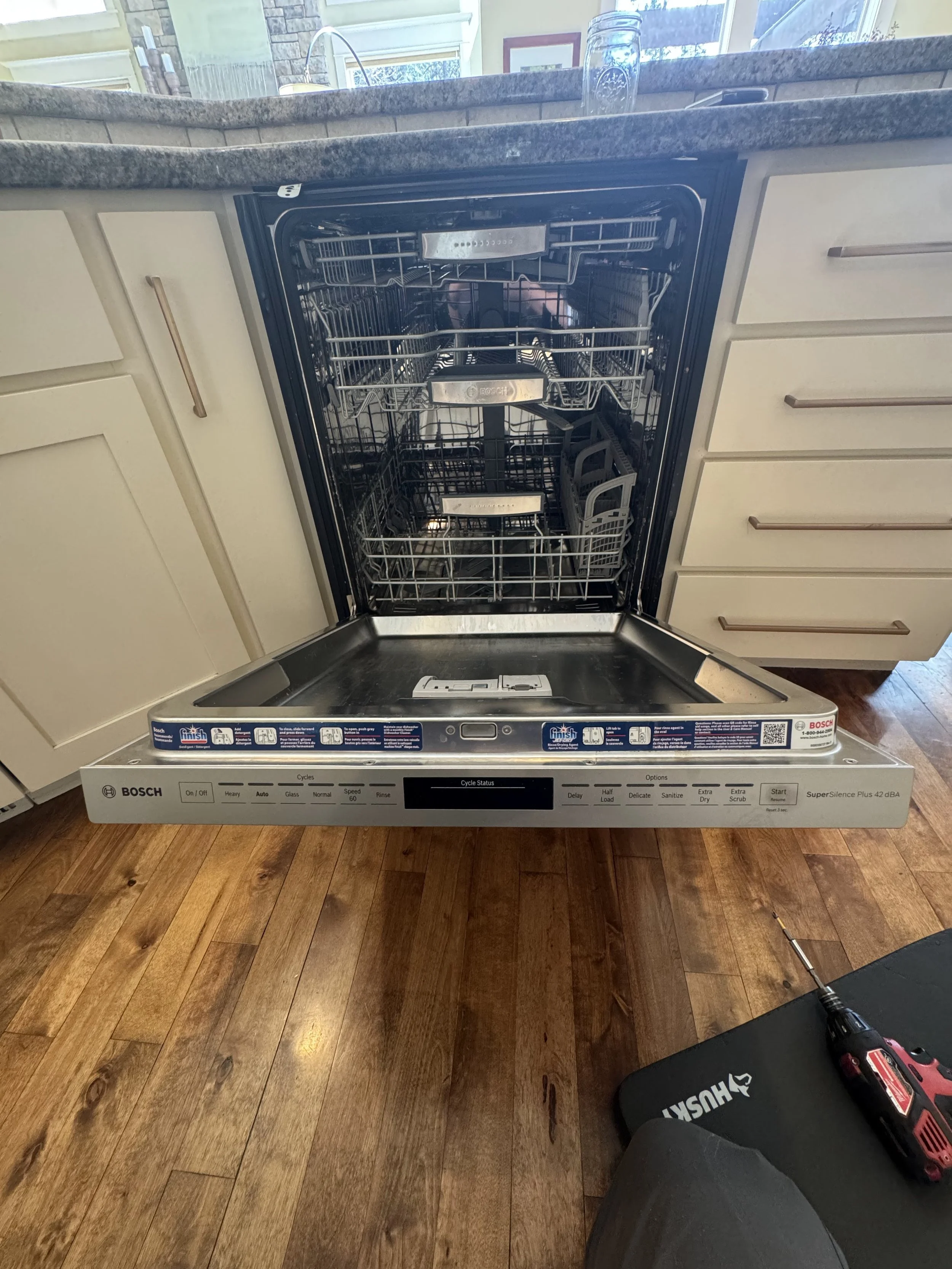 Bosch dishwasher open with its control panel visible, where the hardness setting is matched to the Post Falls water supply
