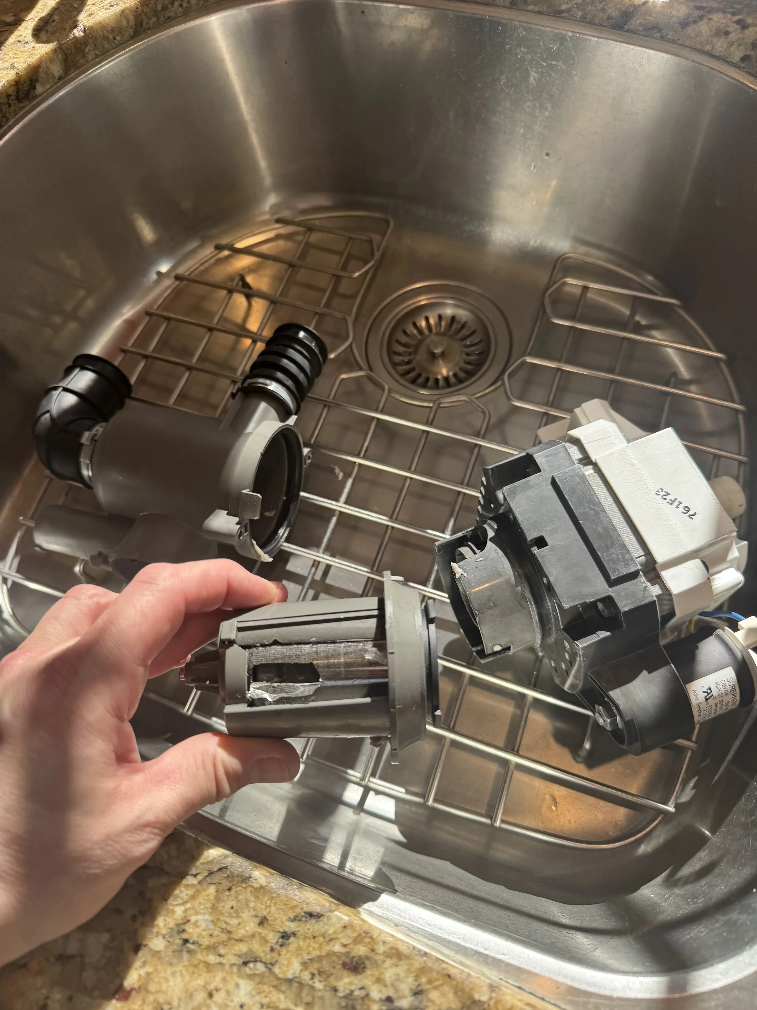 Dishwasher wash arm and pump in hand during a Spokane dishwasher repair by SD Appliance