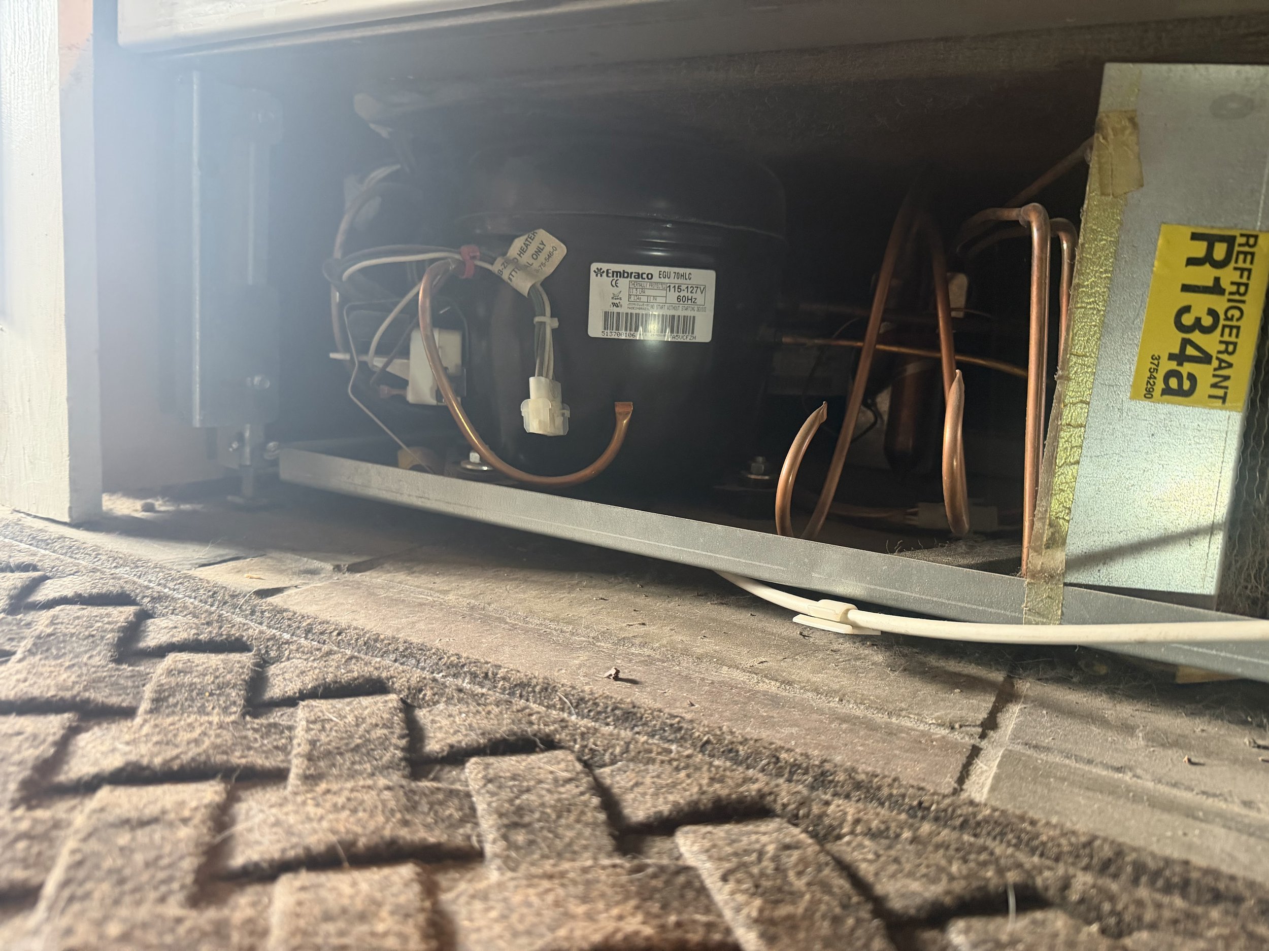 Refrigerator compressor compartment with its R134a refrigerant label, the sealed-system side of a Coeur d'Alene refrigerator diagnosis