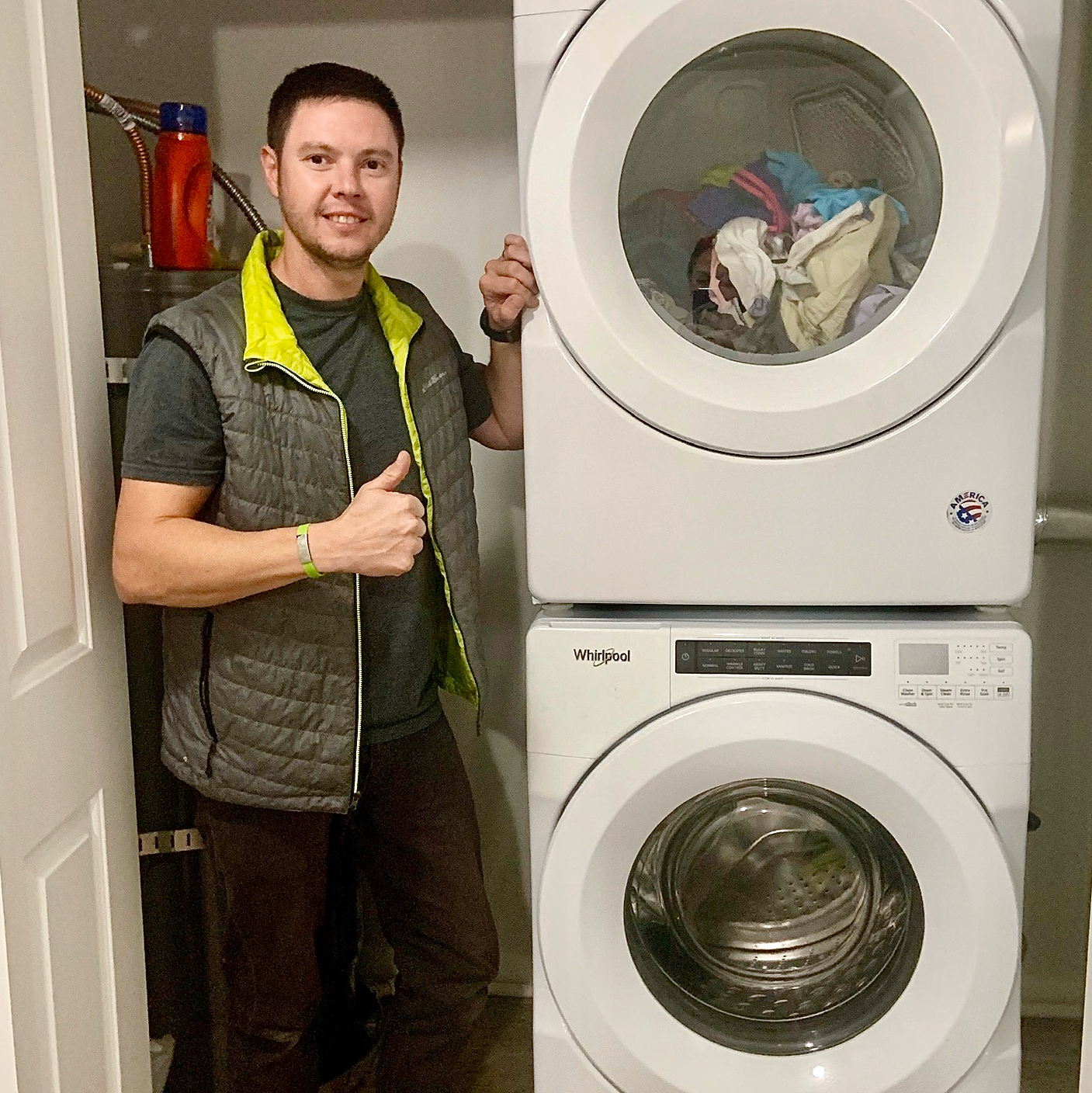 Whirlpool washer being moved into place, the moment its fill hoses and wall taps are in reach during a washer repair in Post Falls