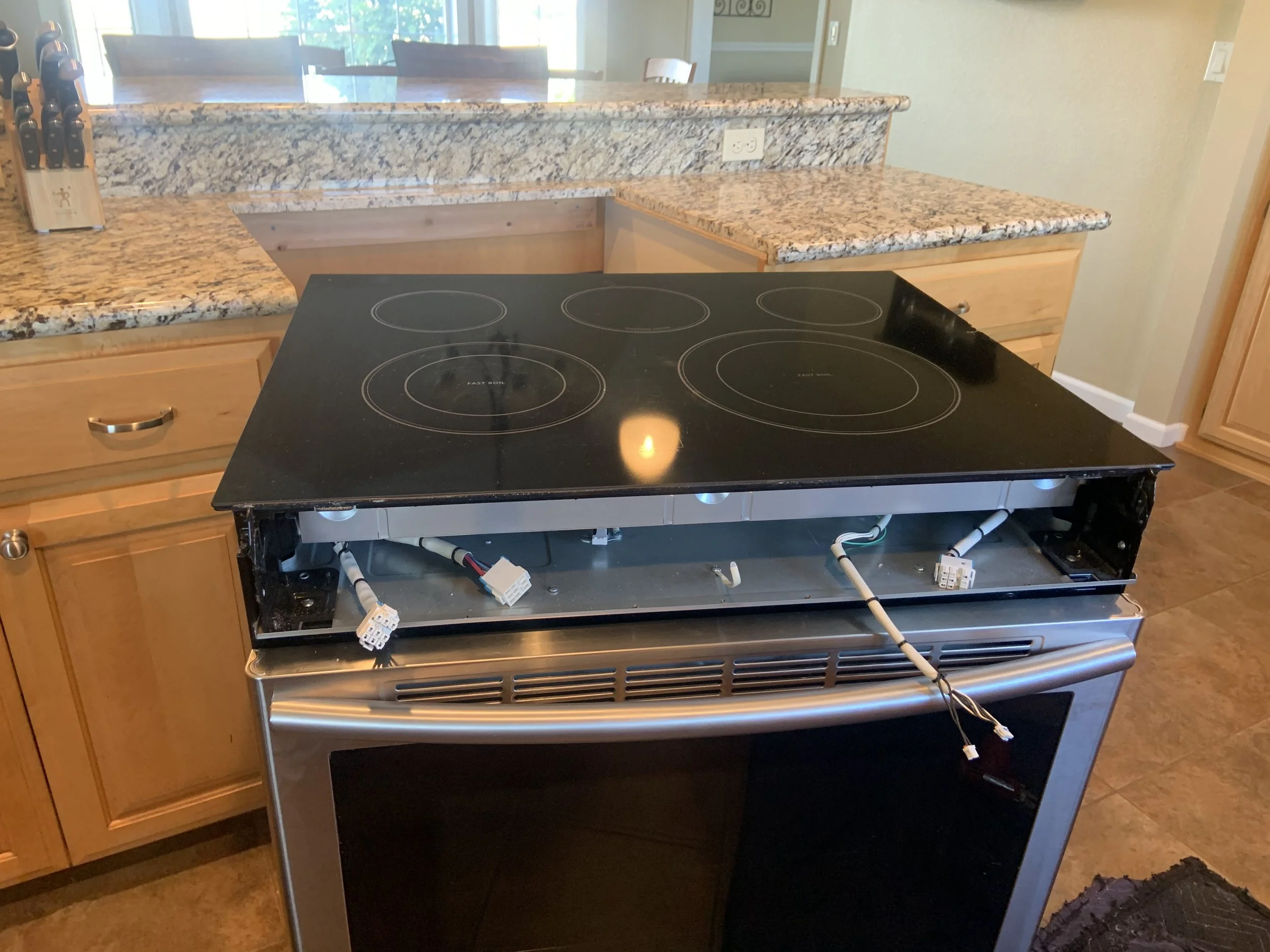 Black glass cooktop with a service tool, range and cooktop repair in a Coeur d'Alene kitchen by SD Appliance