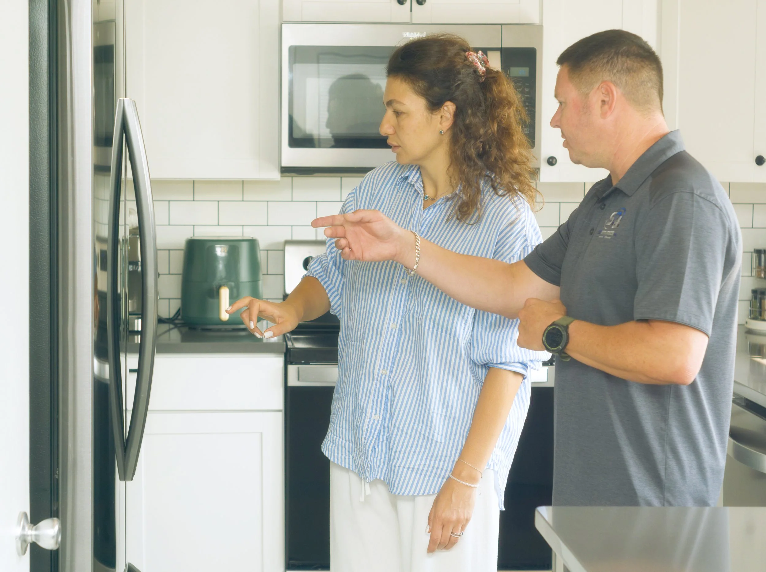 Sergei and a homeowner at the refrigerator, booking a refrigerator visit in Post Falls