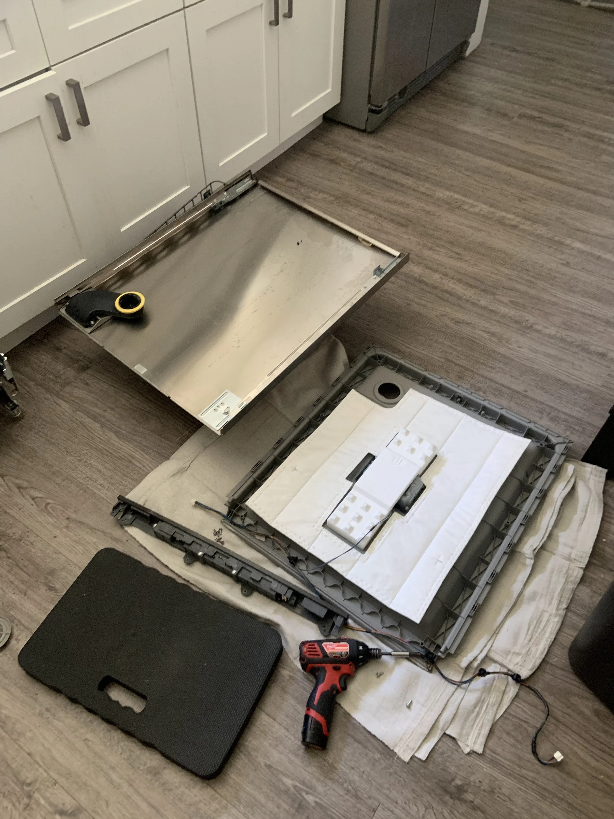 Appliance access panel off, on the floor during a Spokane range hood repair by SD Appliance