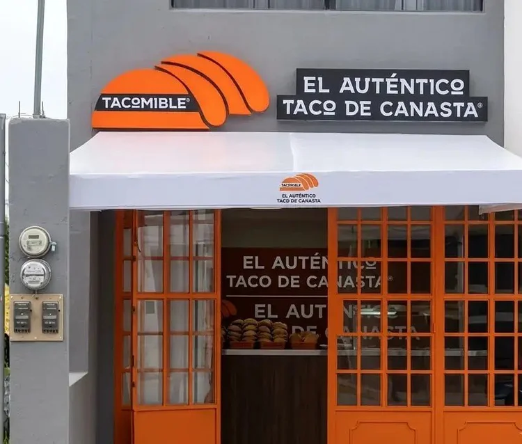 Fachada de Tacomible Centro Sur con puertas naranjas y toldo blanco