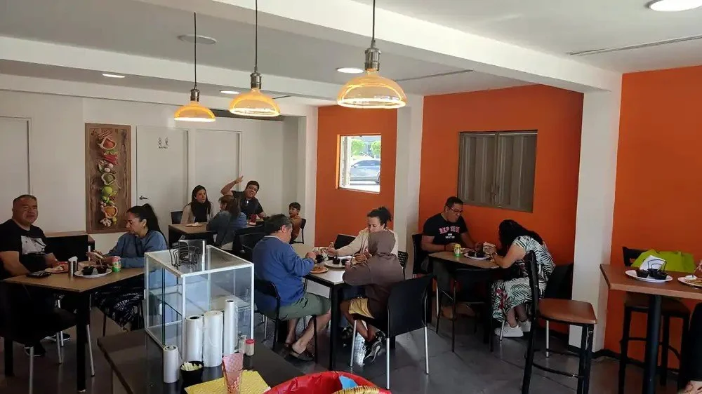 Clientes desayunando tacos de canasta en una sucursal de Tacomible en Querétaro