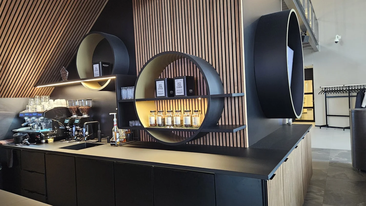 Barwand met ronde stalen ringen als verlichte vitrines