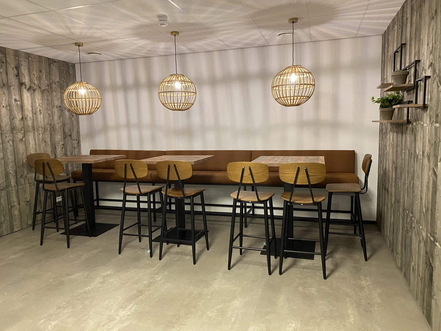 Café-interieur met zwarte stalen statafels en barkrukken