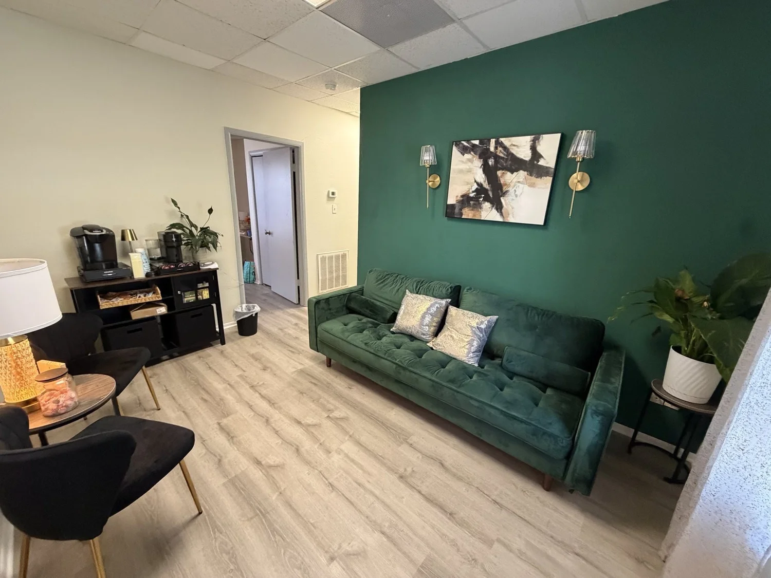PTP waiting area in League City with a green accent wall and velvet sofa