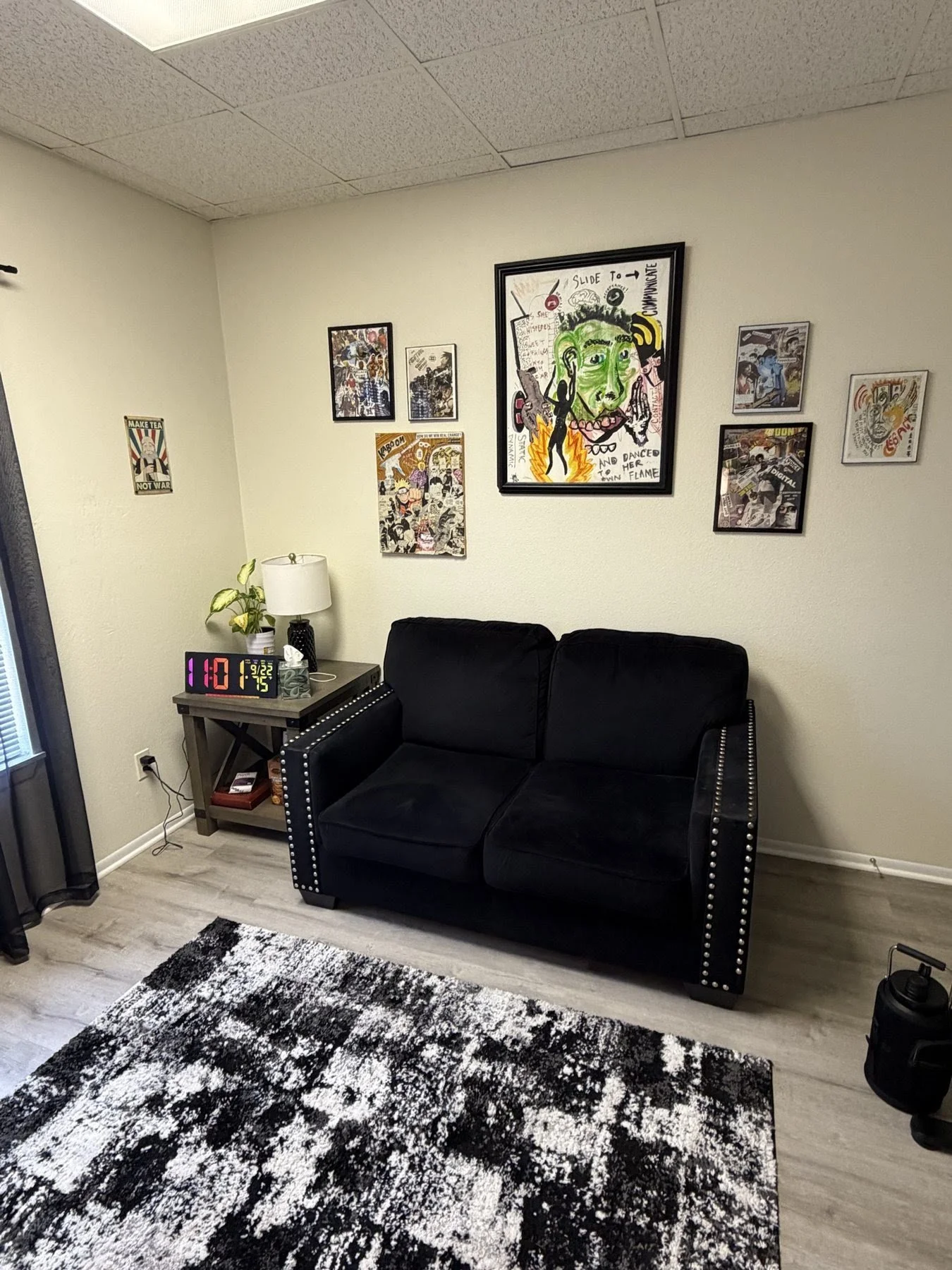 PTP counseling room with a black loveseat and framed art