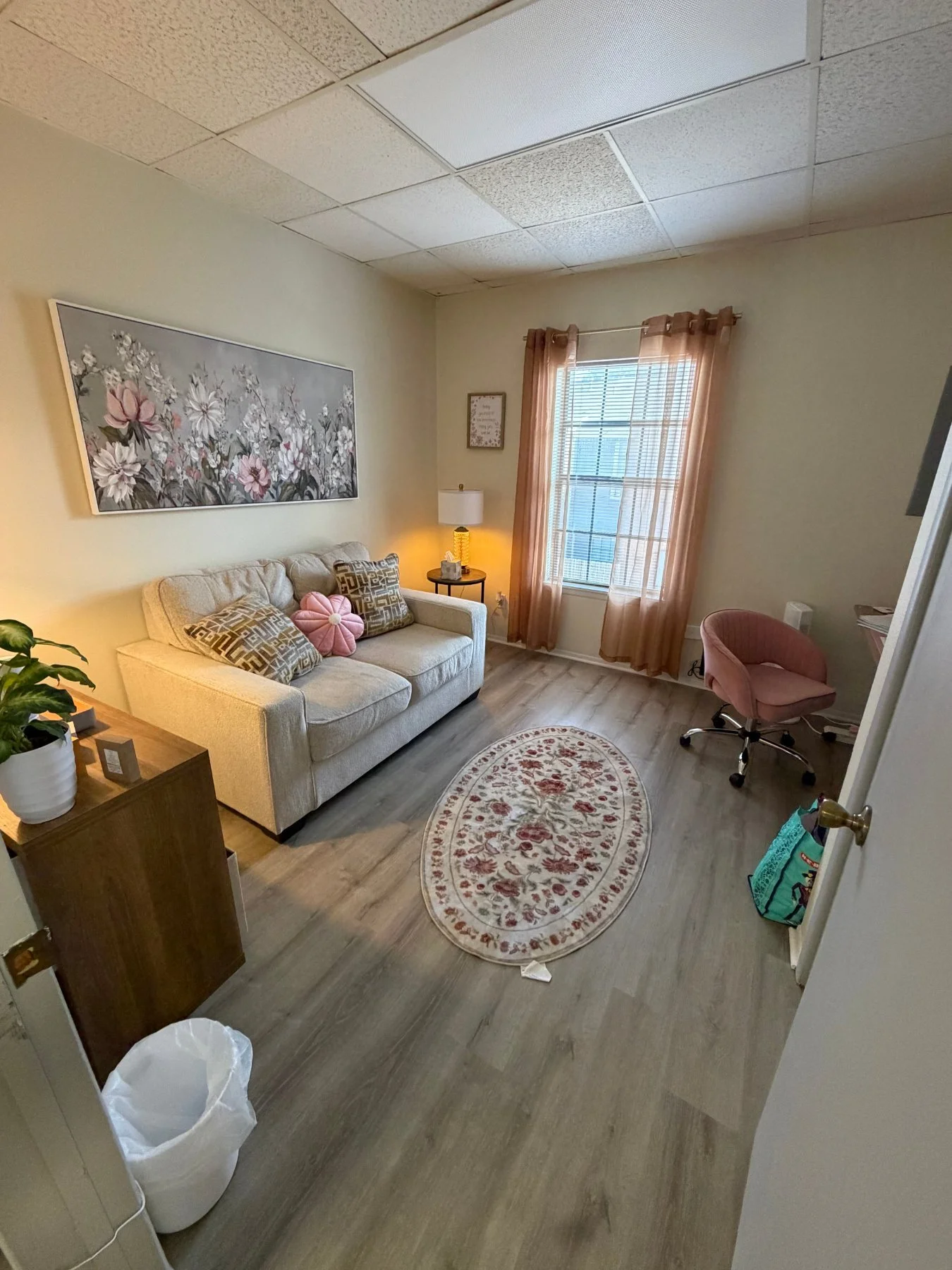 Linda’s counseling room with a cream loveseat and floral art