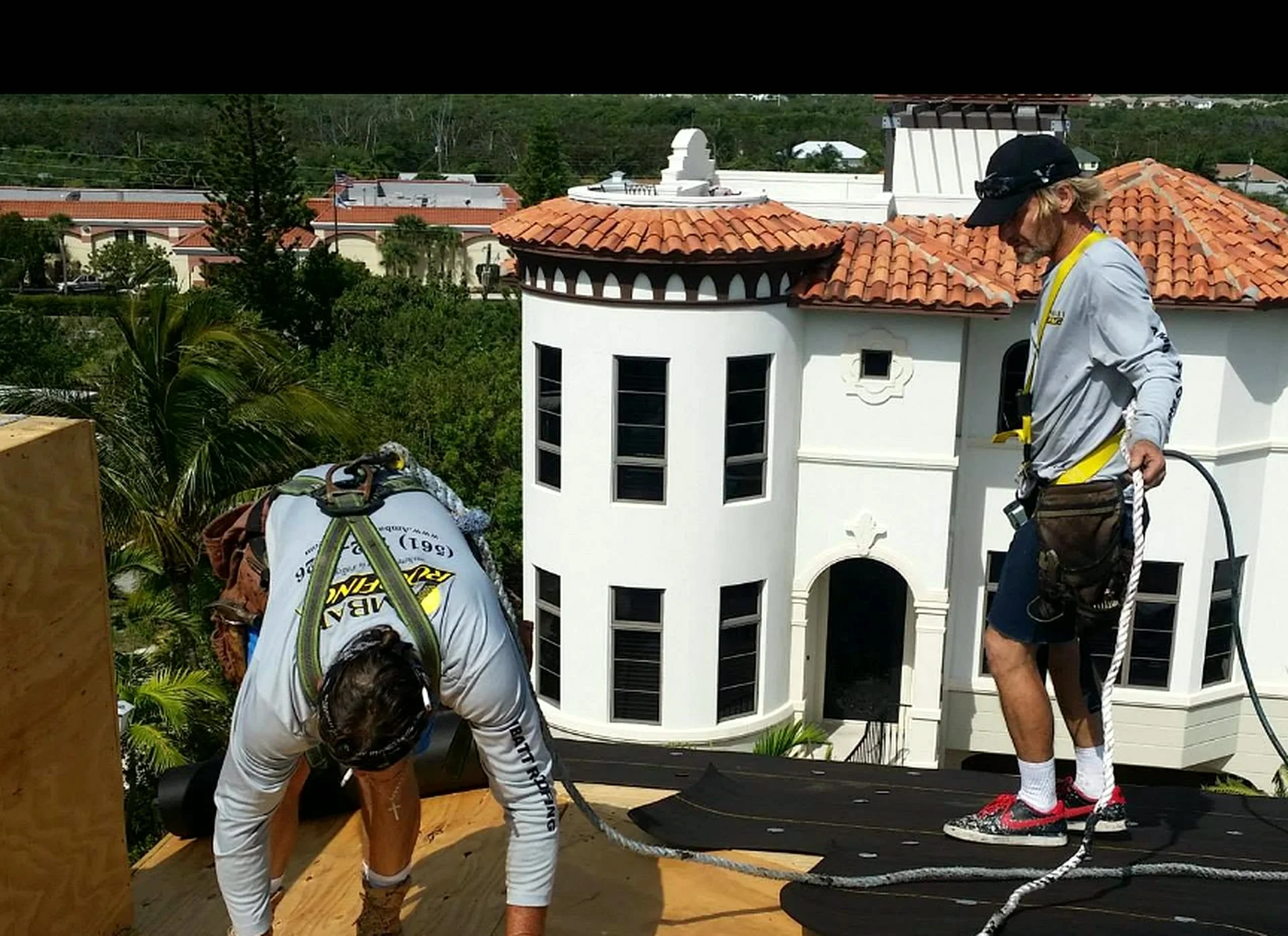 Ambatt Roofing crew installing roof system on a three-story estate home near Jupiter