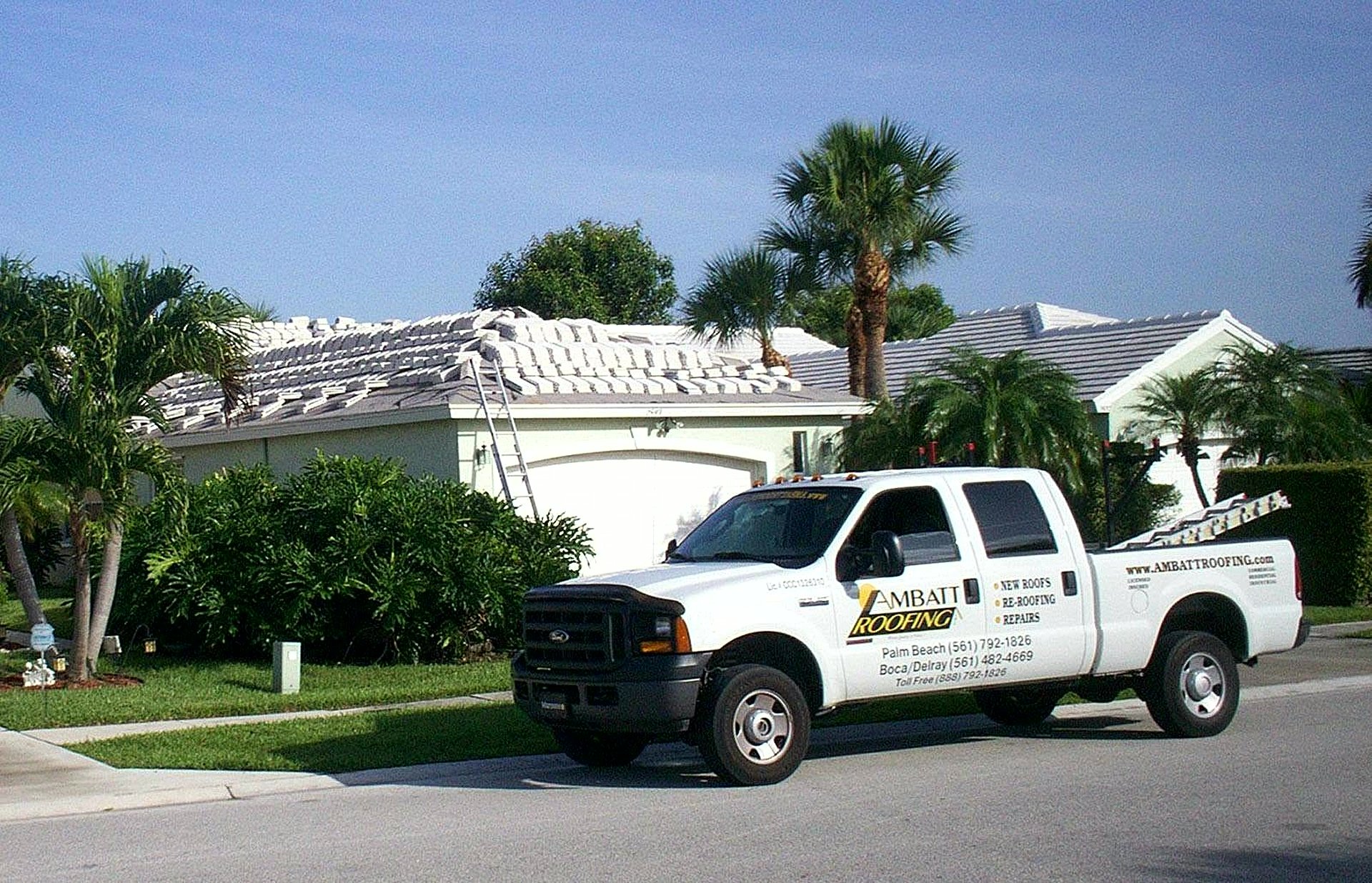 Ambatt Roofing truck beside South Florida tile roof with palms