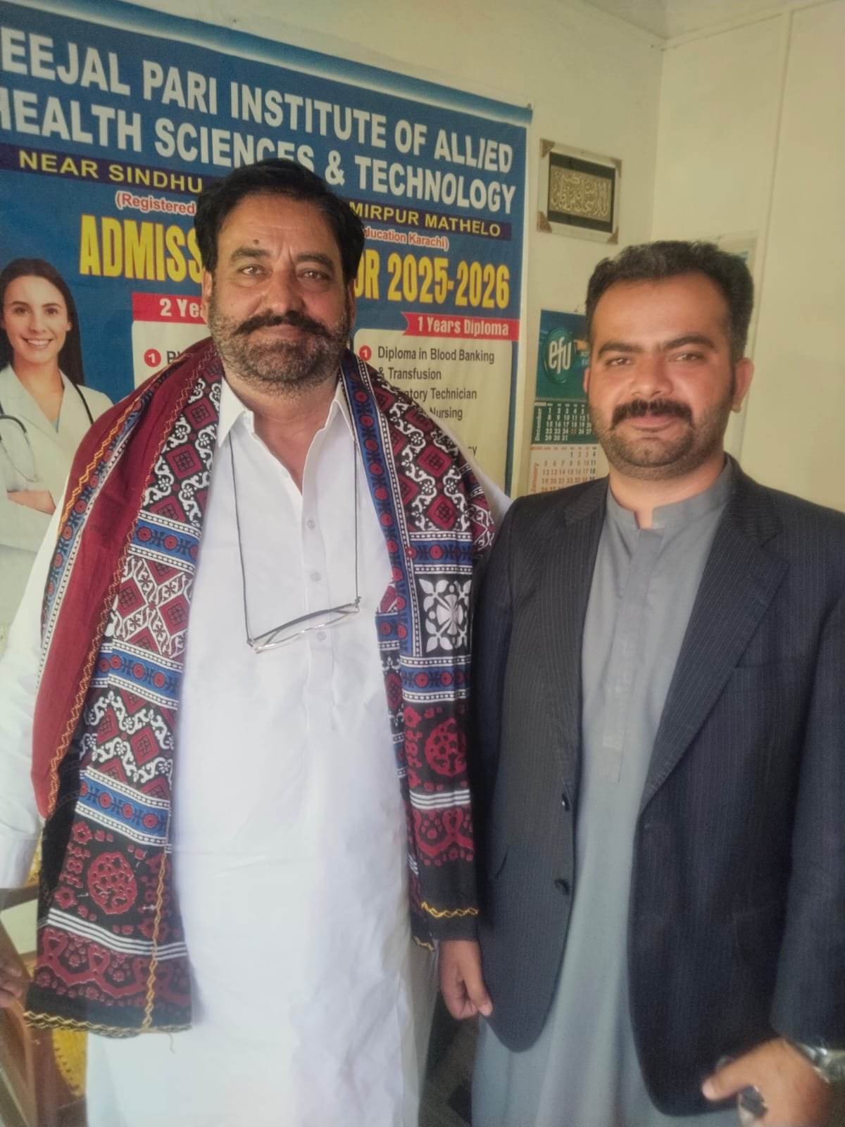 A graduate is presented with a traditional ajrak shawl at a recognition ceremony