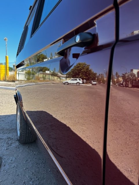 Low-angle view of a burgundy Volkswagen sliding door and paintwork