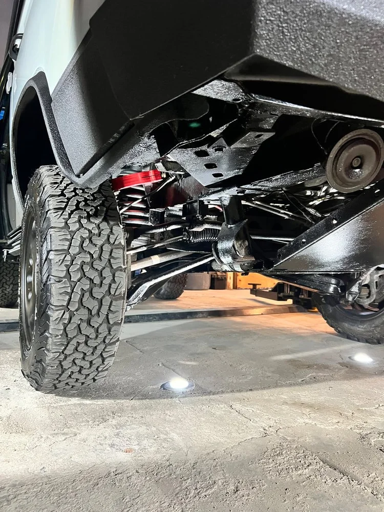 A close-up of springs, suspension components, and tyre clearance.