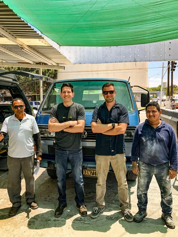 Four people standing together under a workshop shade canopy